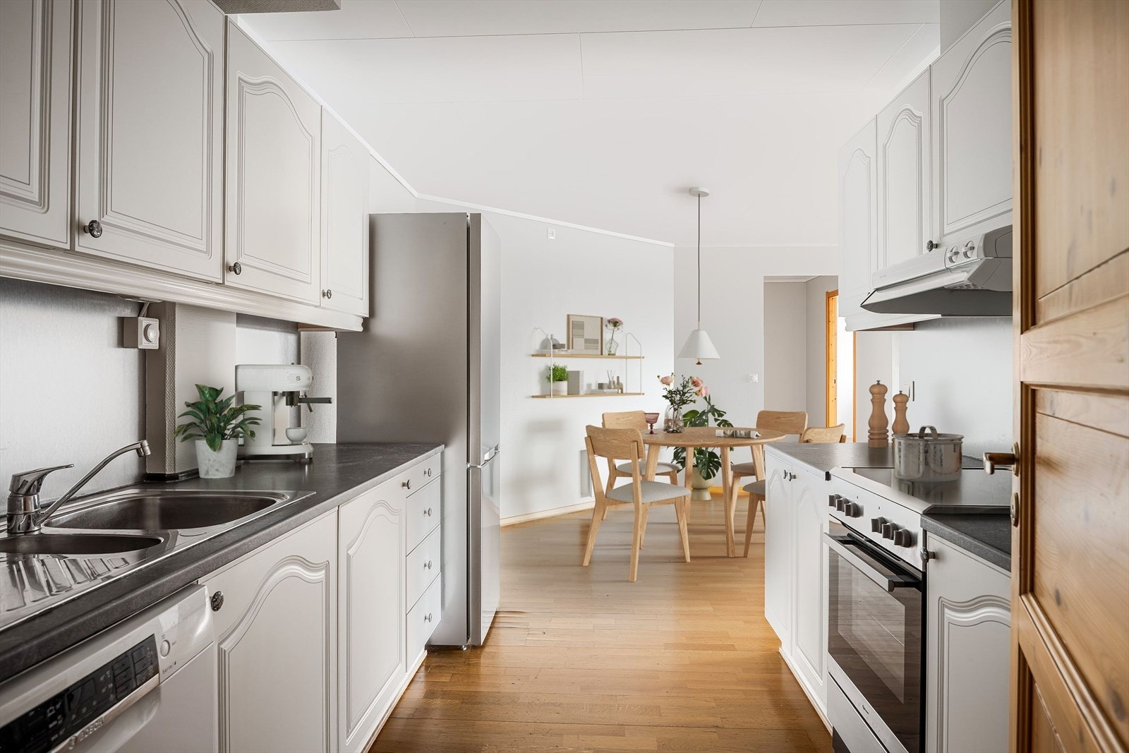 Kjøkkeninnredning med profilerte fronter og benkeplate med laminat. Åpen løsning for hvitevarer som kjøleskap, oppvaksmaksin og stekeovn. Galleribilde