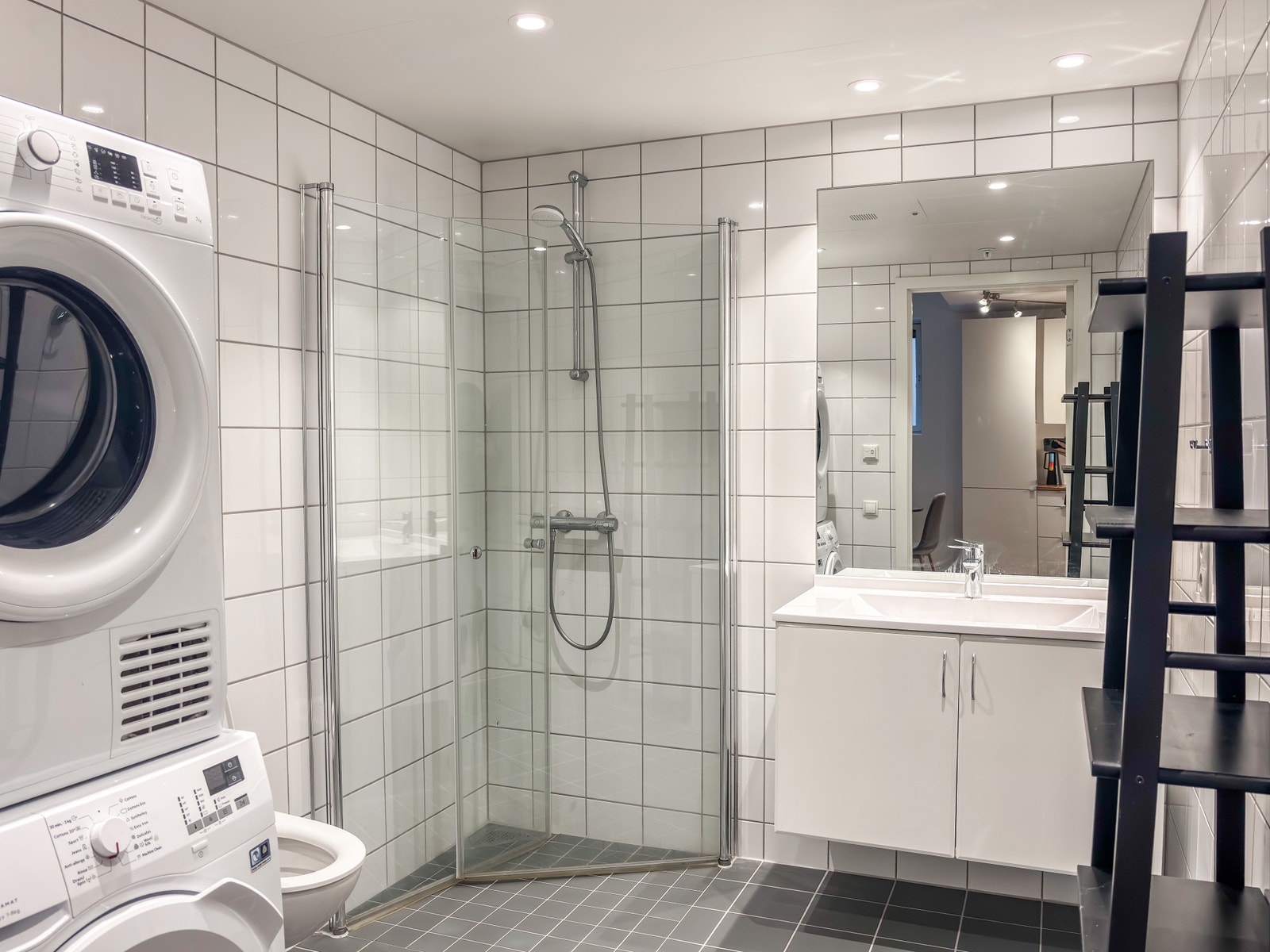 Badet har fliser på gulv og vegger. Tørketrommel og vaskemaskin er inkludert. Galleribilde