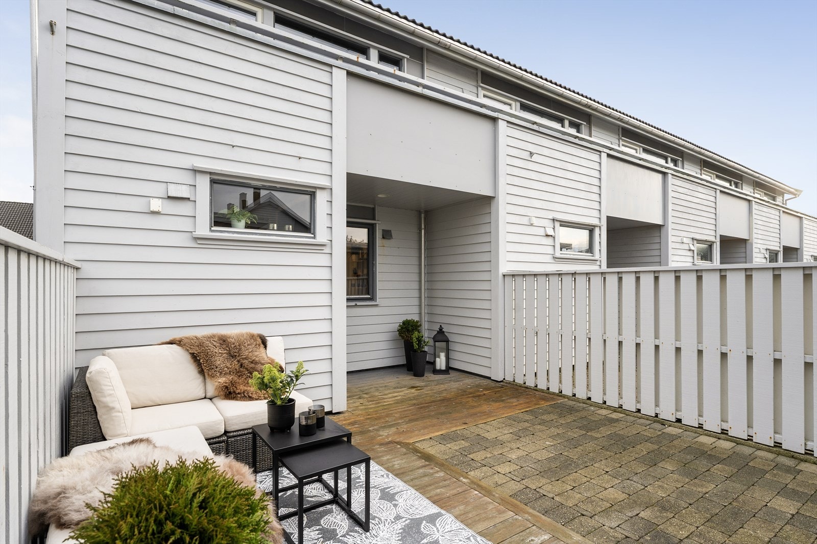 Det usjenerte terrasseområdet er oppført med en kombinasjon av belegningsstein og terrassebord av tre Galleribilde