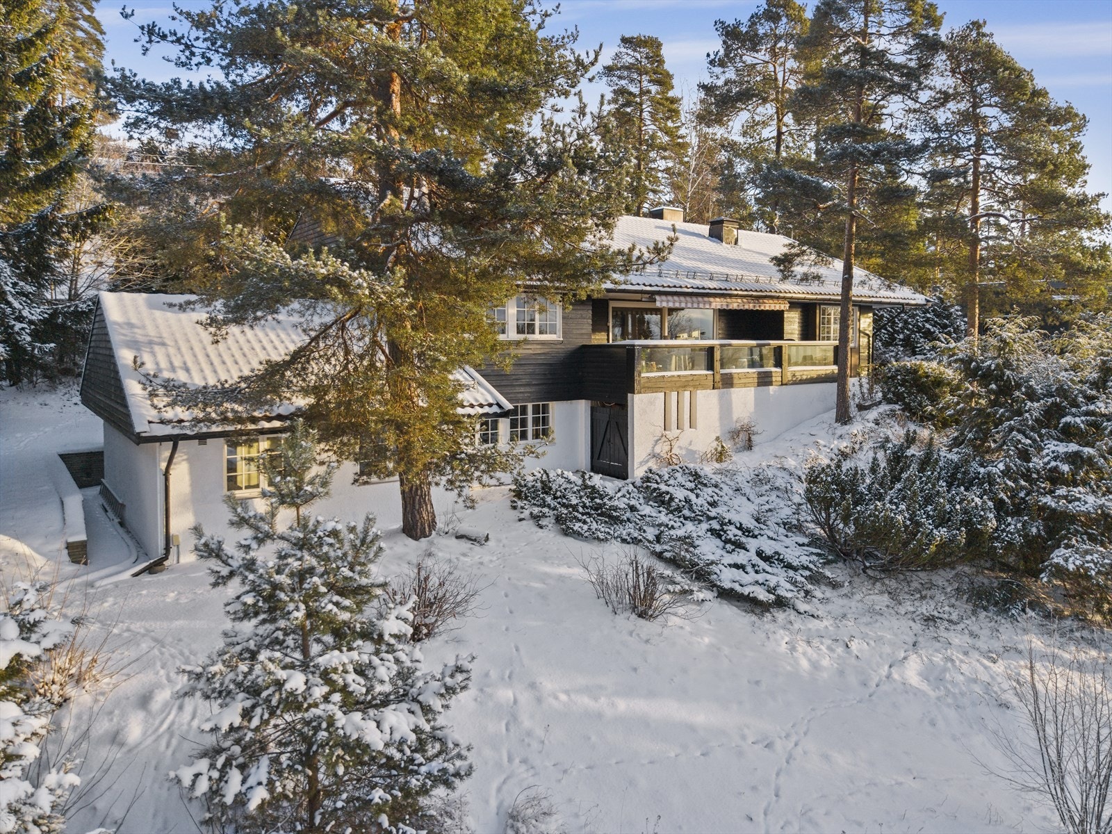 Tomten er pent opparbeidet med gårdsplass, uteplasser, plen og naturtomt Galleribilde