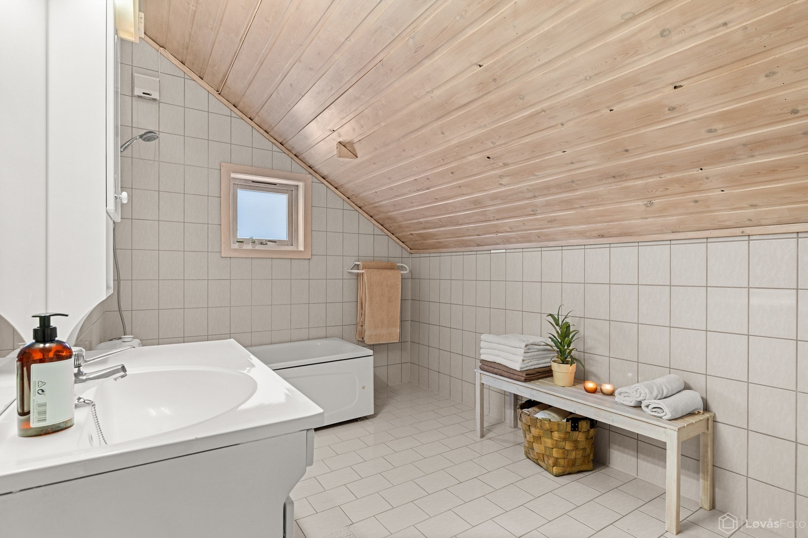 Det er god plass på badet, og skråtaket i trepanel gir rommet en varm atmosfære. Galleribilde