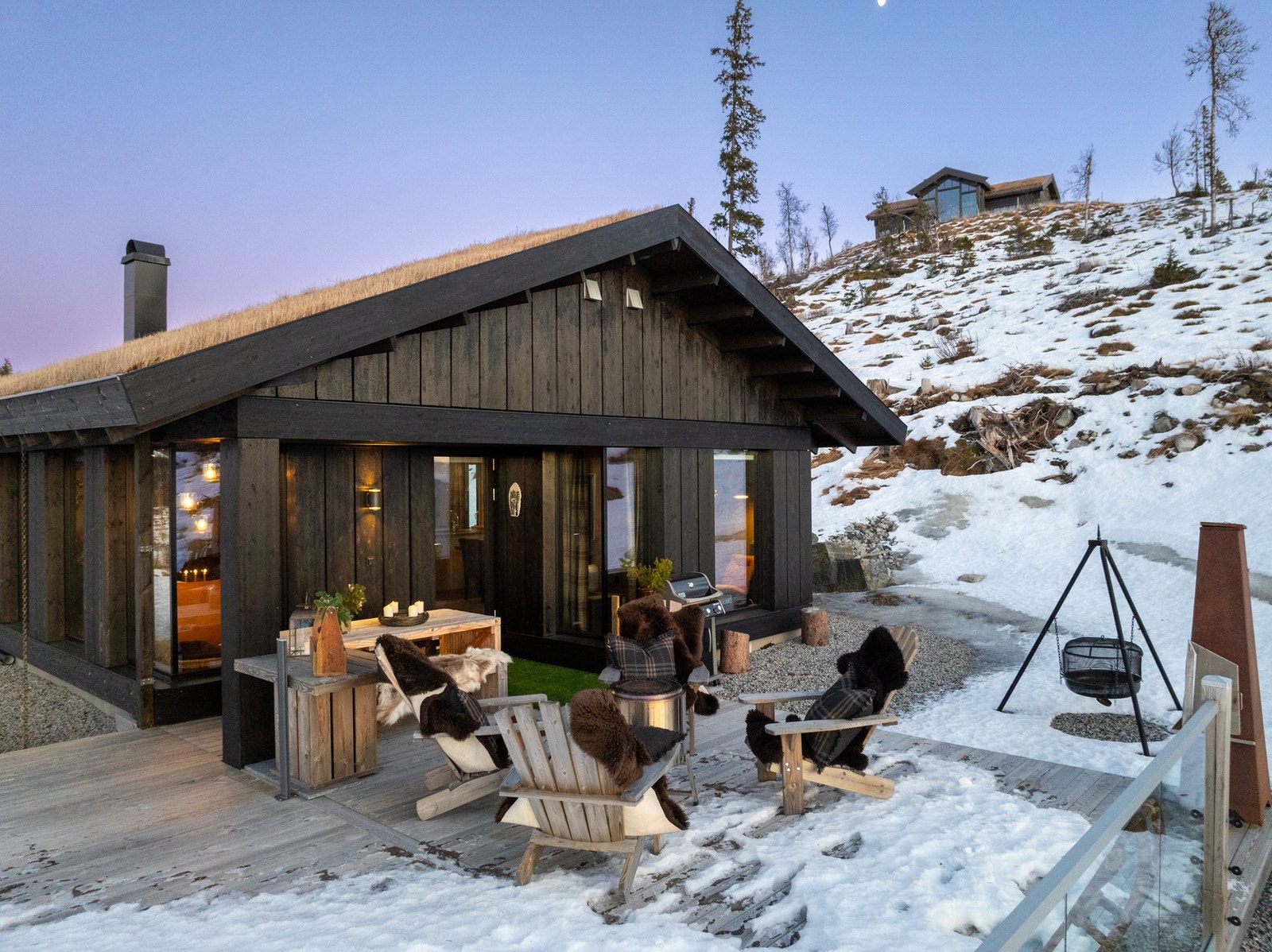 Terrasse med utgang fra stuen med glassrekkverk og utepeis. Galleribilde