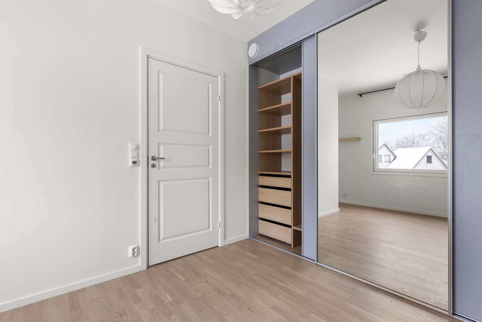 Det er montert et stort skyvedørsgarderobeskap med praktisk innredning Galleribilde