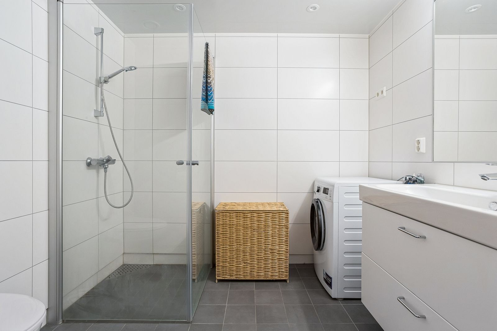 Lyst og tiltalende bad. Innredet med baderomsinnredning, wc og dusj. Vaskemaskin - Galleribilde