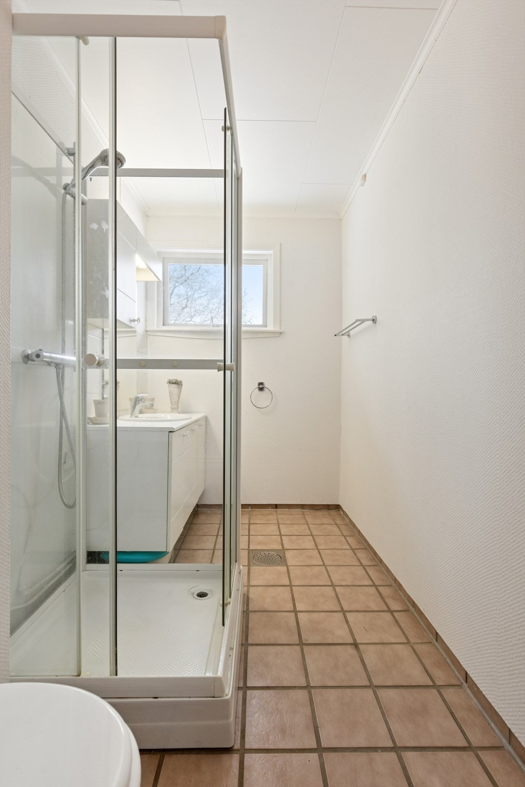 Eldre bad bestående av toalett, dusjkabinett og servant. Galleribilde