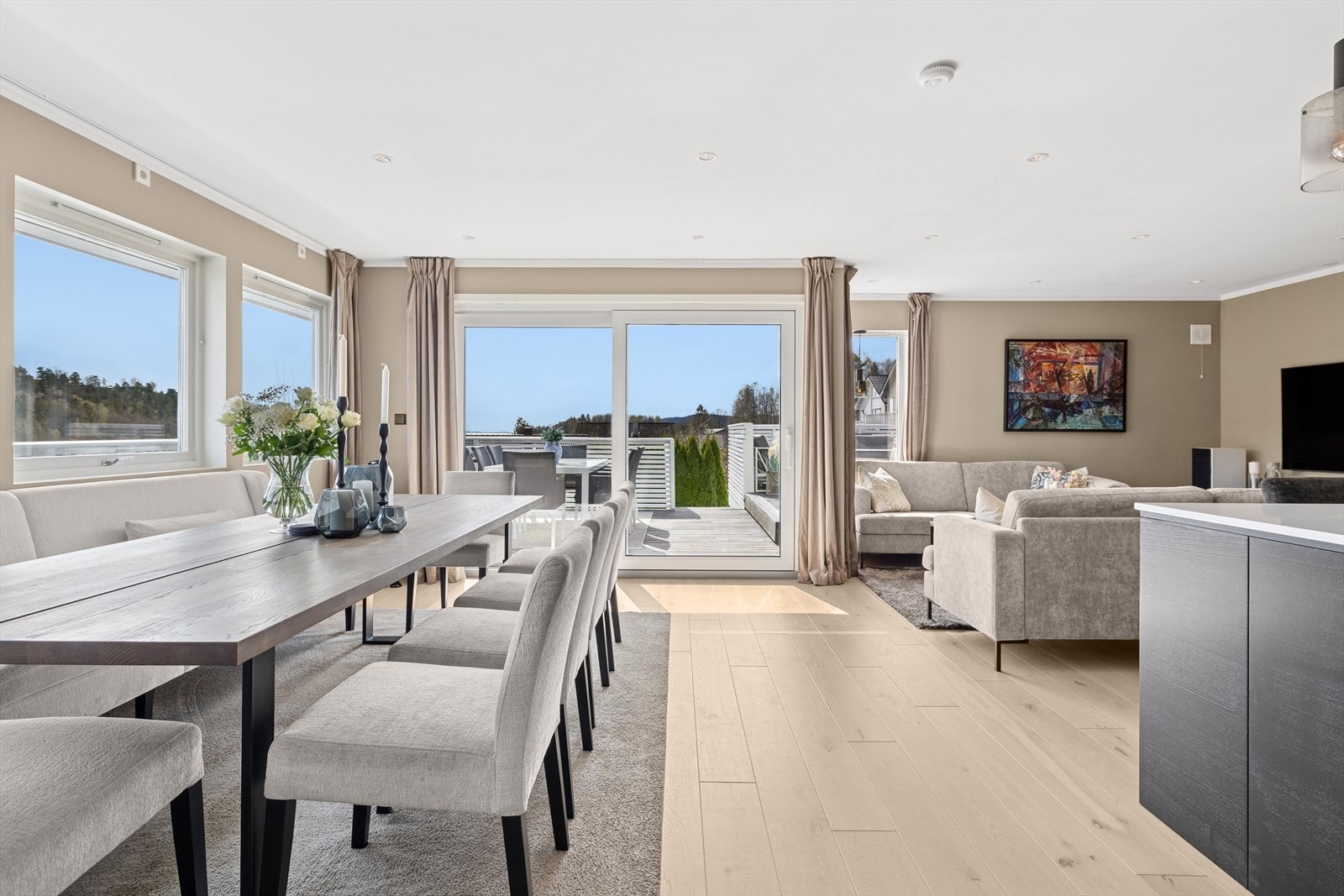 Romslig stue med god plass til sofagruppe, TV-møblement og stort spisebord Galleribilde