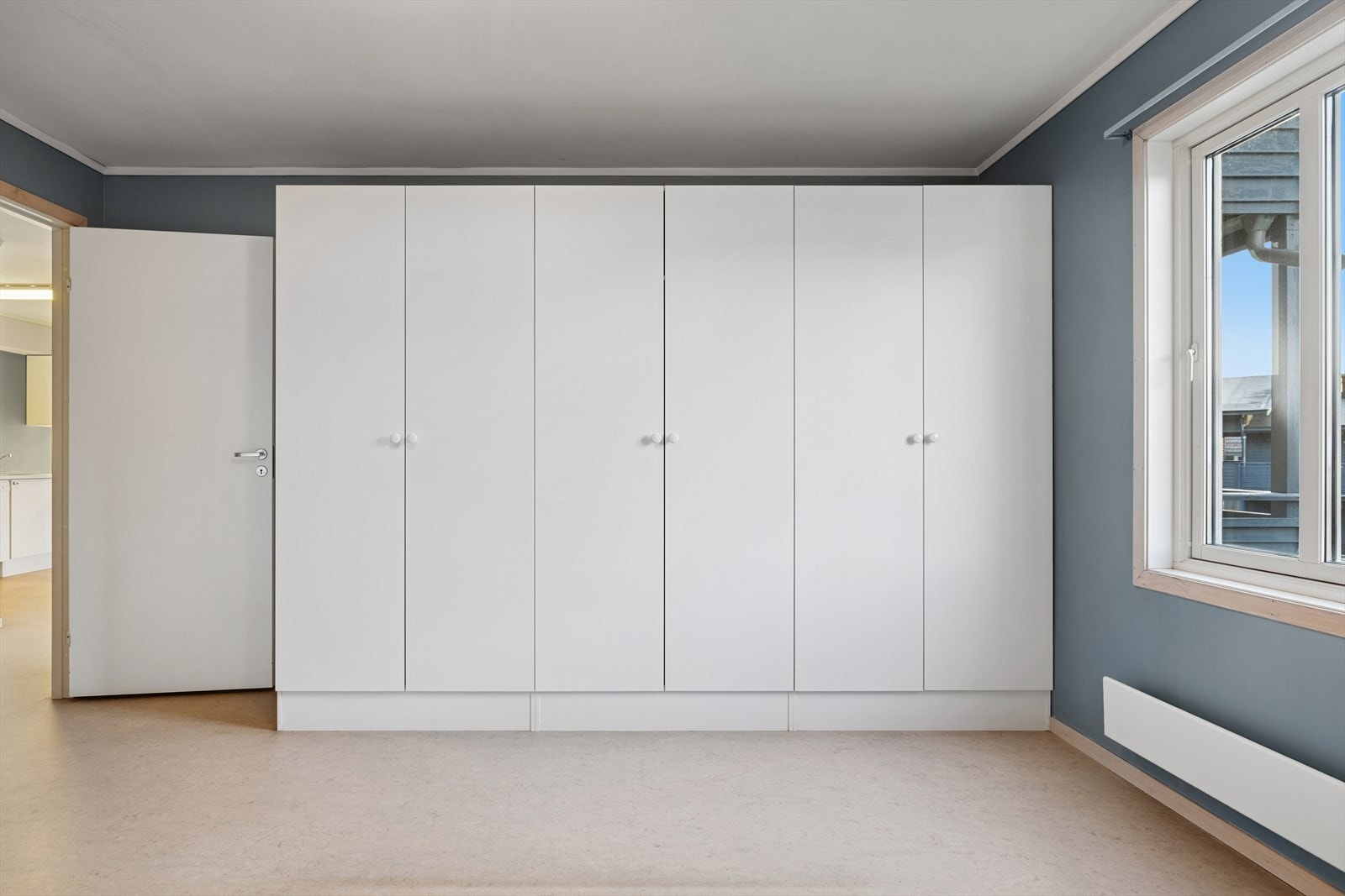Garderobeløsning på soverommet med hvite fronter gir effektiv oppbevaring. Galleribilde
