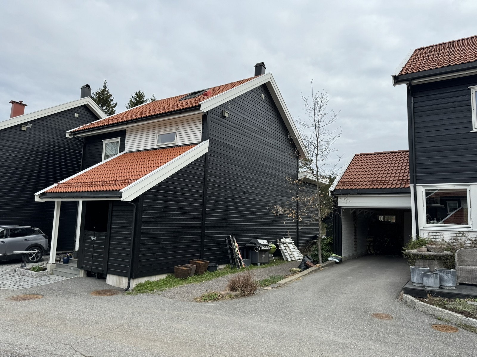 Garasje til en bil og oppstillingsplass foran garasjeplass. Galleribilde