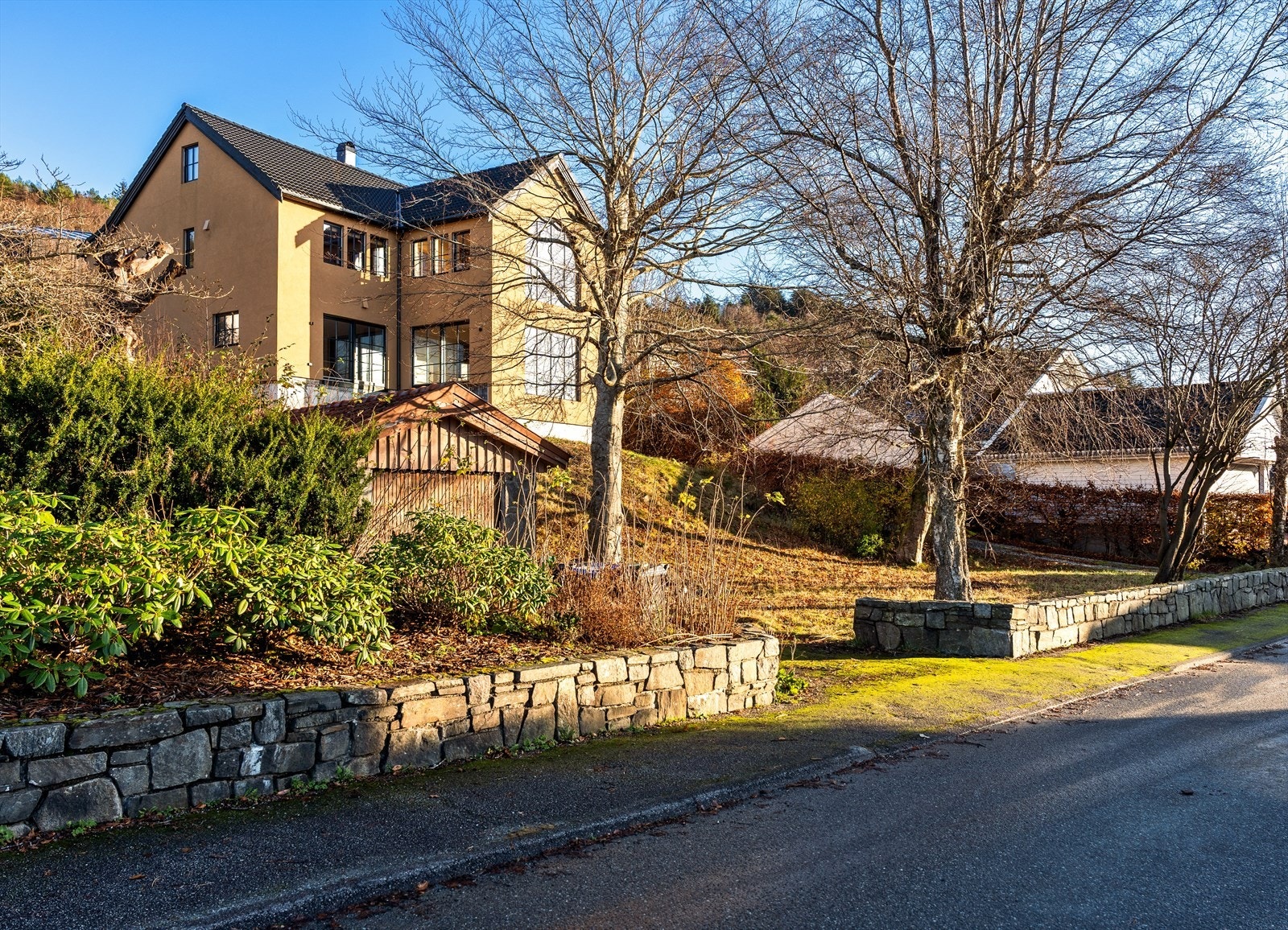 Du møtes av en flott eiendom omkranset av natursteinsmur, med arkitektonisk fremtoning og høytliggende plassering. Galleribilde