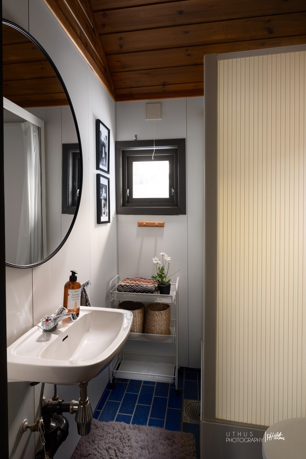 Badet er innredet med en servant, overhengende speil og belysning. Dusjkabinettet er plassert i hjørnet og har håndholdt dusjarmatur. Videre er det montert et gulvstående toalett. Galleribilde