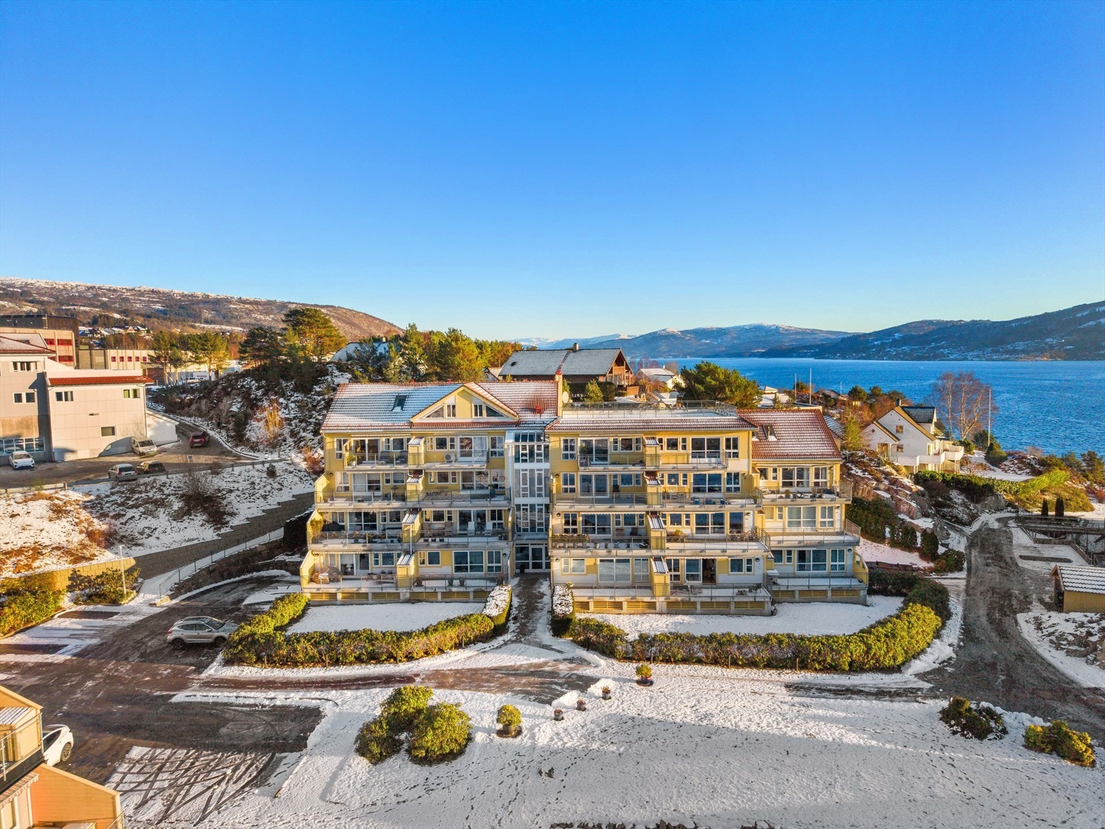 Parkering kan gjøres utendørs på felles biloppstillingsplass nord for boligblokken. Galleribilde