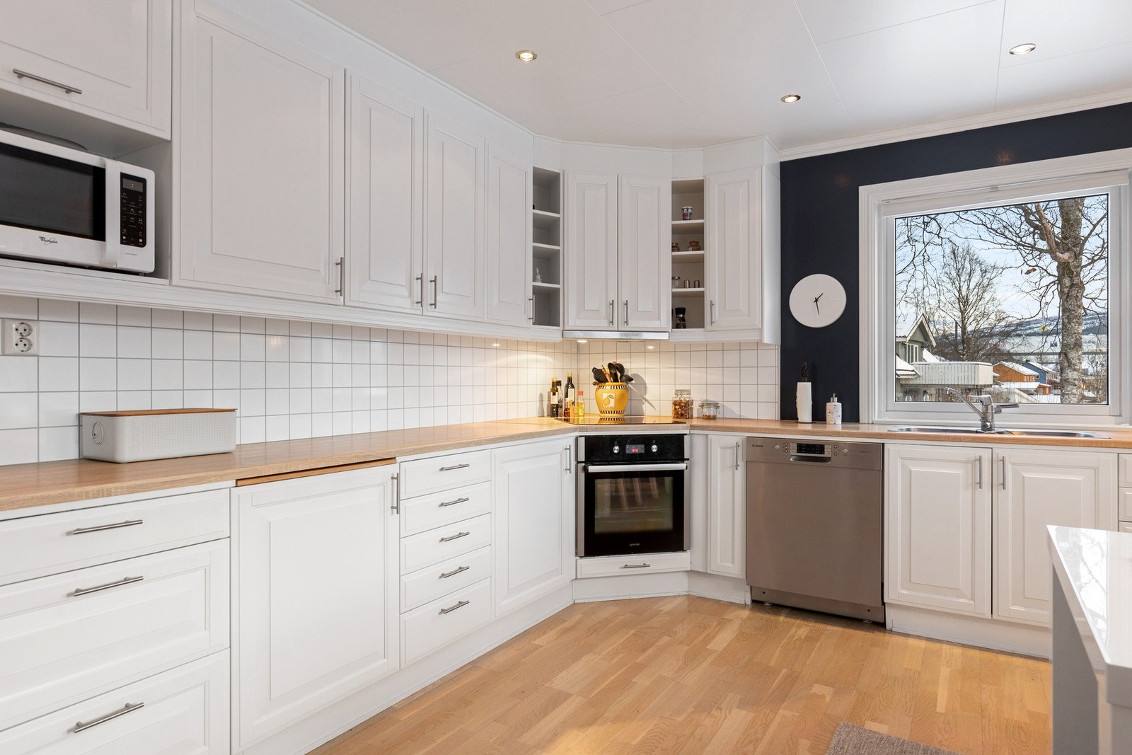 Integrerte hvitevarer, inkludert induksjonstopp og stekeovn fra ca. 2018, gir et stilrent og effektivt kjøkken. Galleribilde