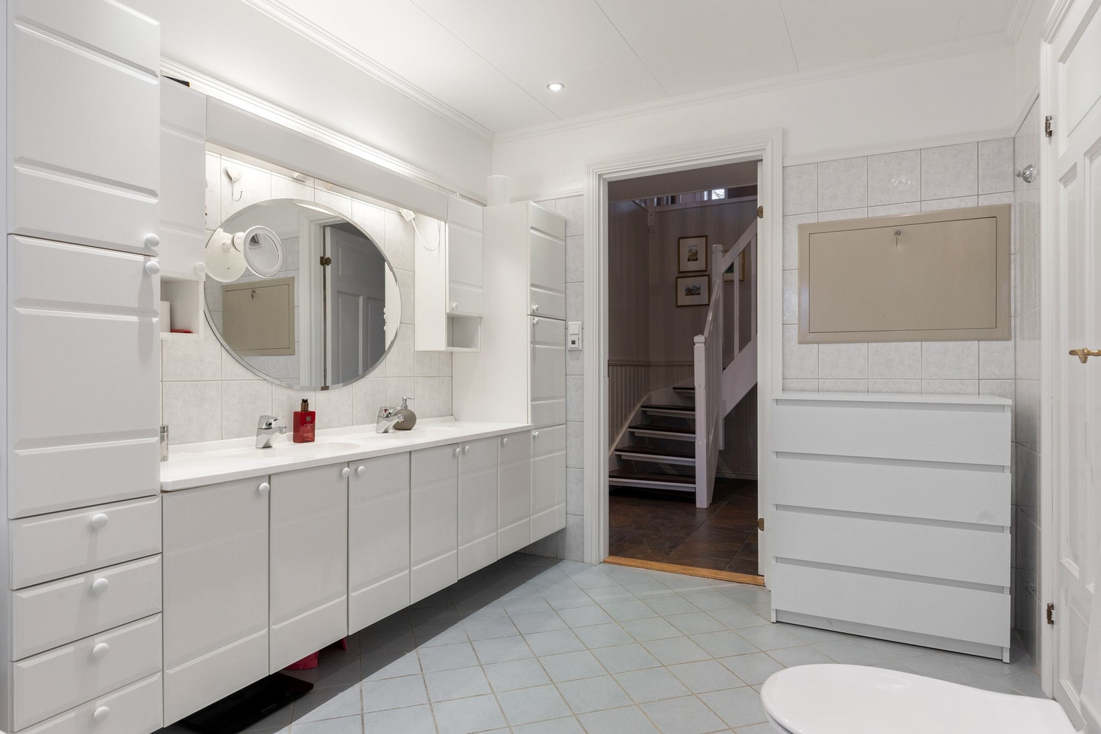 Flislagte vegger kombinert med malte flater gir badet et lyst og ryddig uttrykk. To servanter skaper en praktisk flyt ved morgen og kveldsstell. Galleribilde