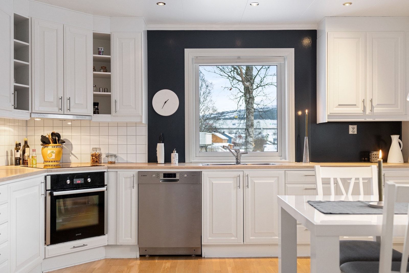 Lyse overflater kombinert med parkett på gulv gir kjøkkenet et lyst og innbydende preg. Mekanisk avtrekk med utlufting direkte til yttervegg bidrar til god ventilasjon ved matlaging. Galleribilde