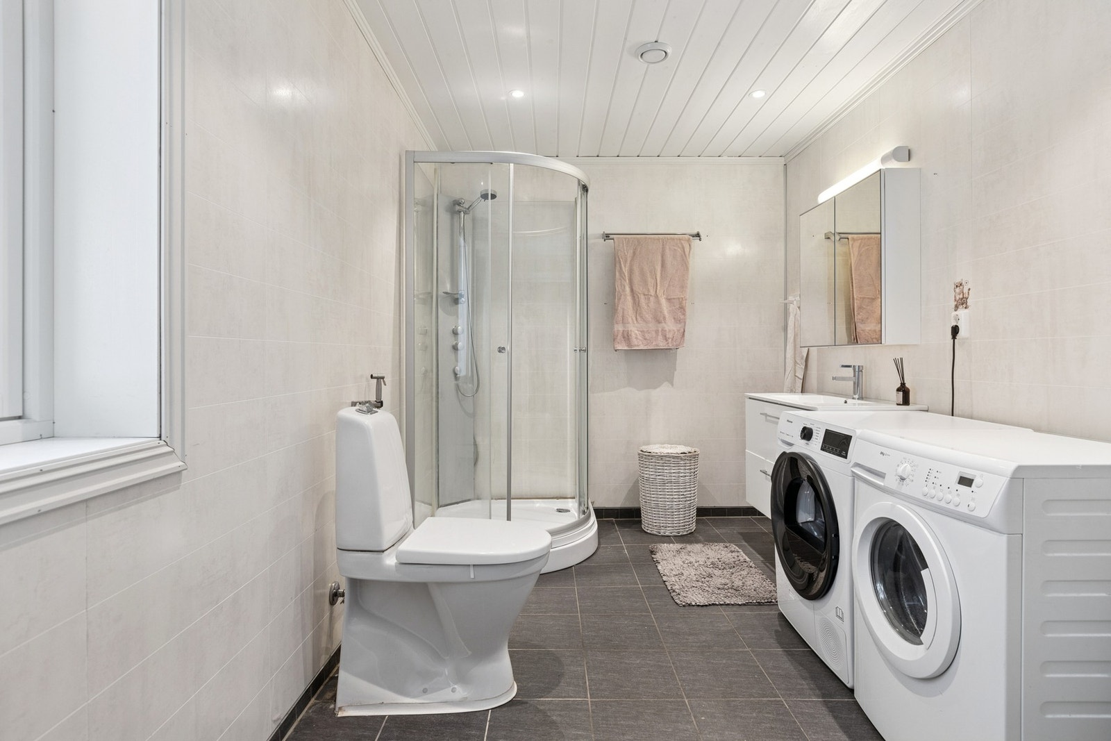 Badet er utstyrt med dusjhjørne, vegghengt servantinnredning med ovenpåliggende servant samt WC. Galleribilde