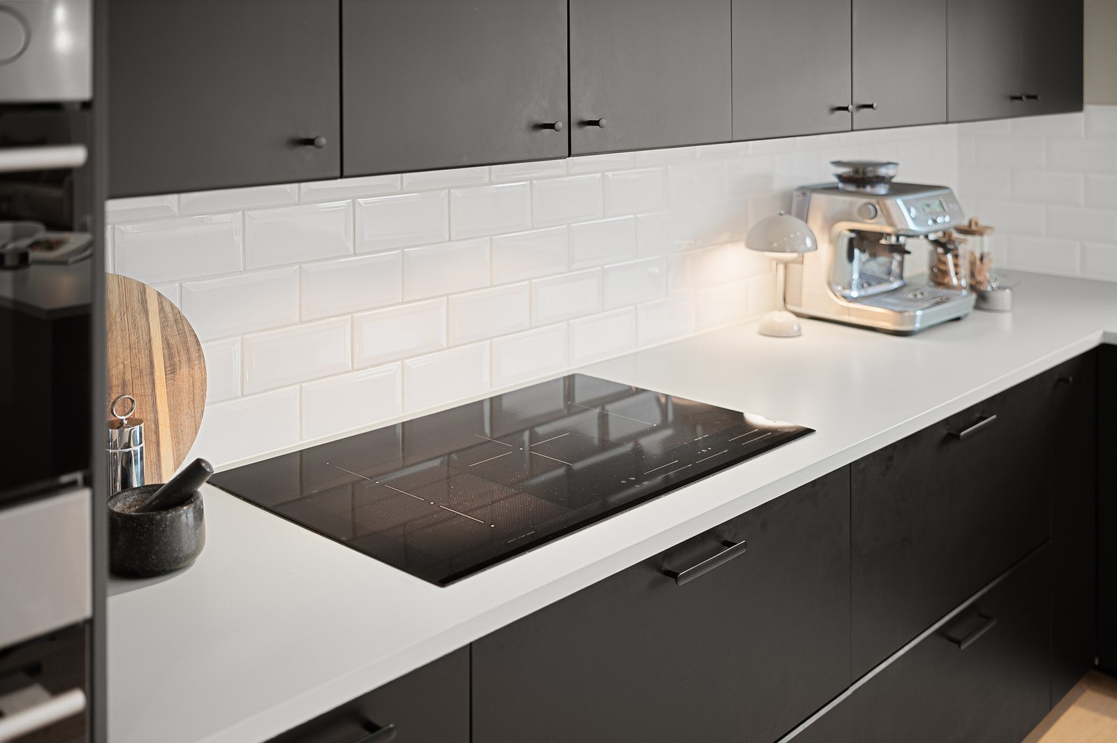 Kjøkkenets arbeidsområde med induksjonstopp og romslig benkeplate, tilrettelagt for effektiv matlaging. Galleribilde