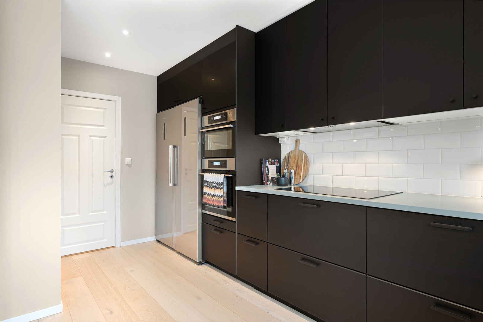 Funksjonell kjøkkenvegg med helintegrerte løsninger, rene linjer og god sammenheng mellom arbeidssone og oppbevaring. Galleribilde