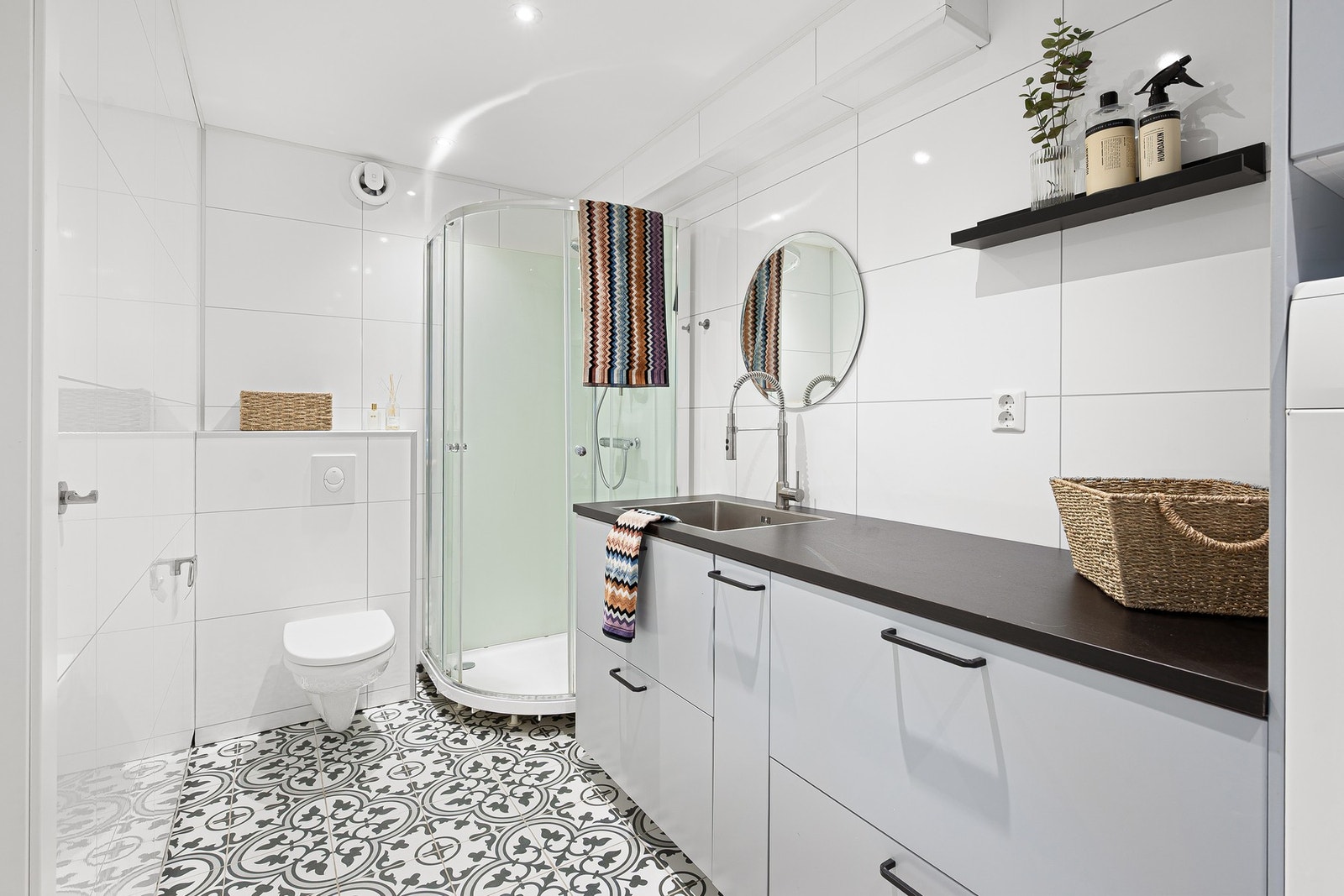 Vaskerommet har stor arbeidsbenk, opplegg for vaskemaskin samt vegghengt WC og dusjkabinett. Galleribilde