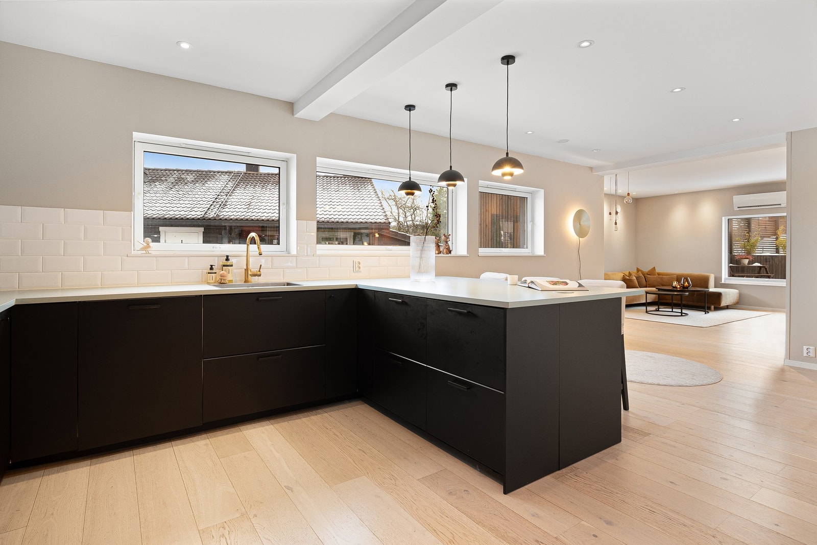 Kjøkken sett fra motsatt vinkel, med god benkeplass, rikelig oppbevaring og sømløs overgang mot stue. Galleribilde