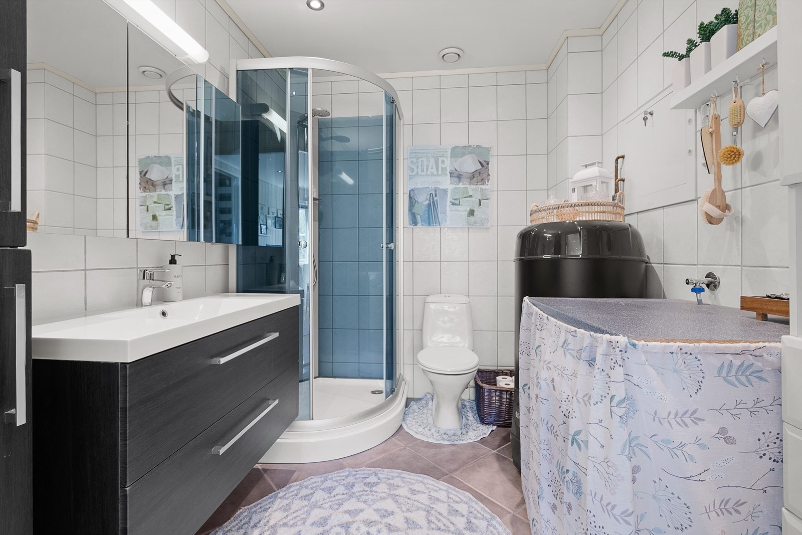 Badet er er flislagt med varmekabler i gulv og inneholder servant med skap, dusjkabinett, toalett og opplegg til vaskemaskin. Det er installert nyere, energisparende varmtvannstank. Galleribilde