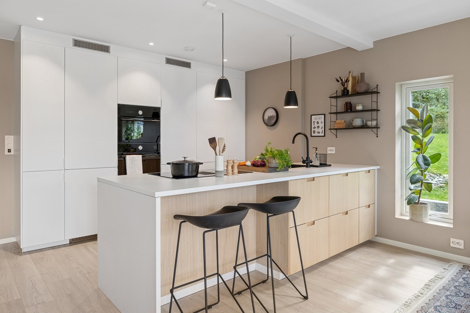 Meget pent og funksjonelt kjøkken fra byggeåret 2021, levert av IKEA. Kjøkkenet har en åpen løsning med kjøkkenøy. Overflater består av lyse slette fronter, laminerte benkeplater med nedfelt oppvaskkum i svart kompositt. Galleribilde