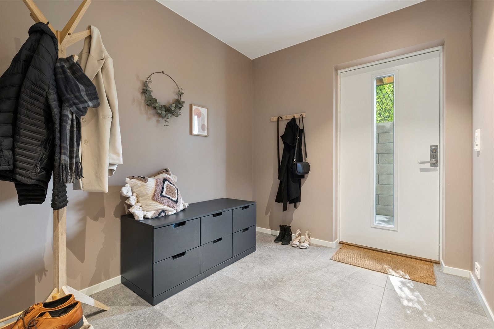 Velkommen inn i en romslig og lys entre med inngang fra bakkeplan. Galleribilde