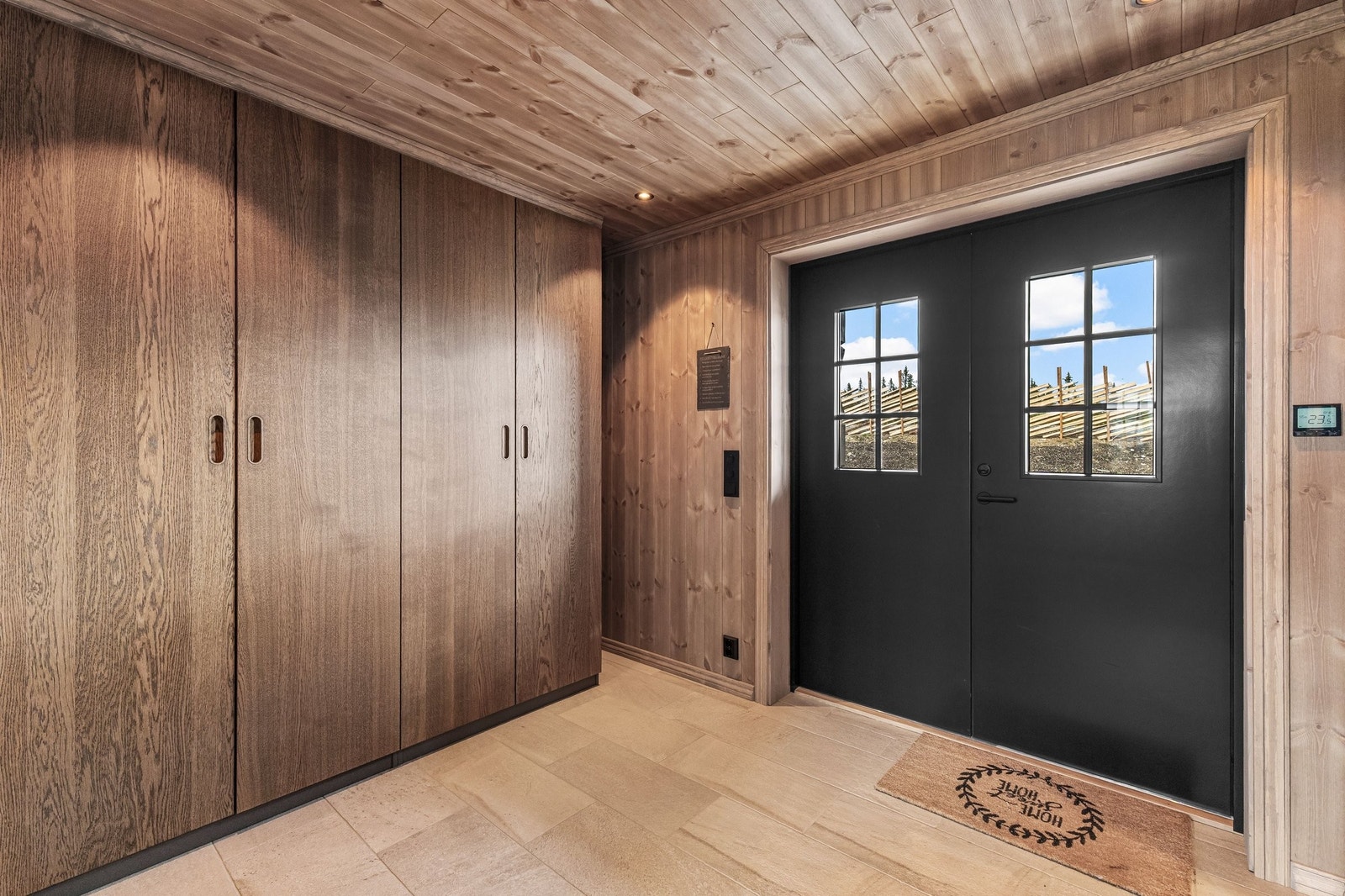 Vel inne blir vi ønsket velkommen i en nydelig hall som gir et utmerket førsteinntrykk av den store, elegante hytta. Her er det romslig garderobeplass, flislagt gulv, og i likhet med resten av første etasje er det vannbåren varme i gulvet. Galleribilde