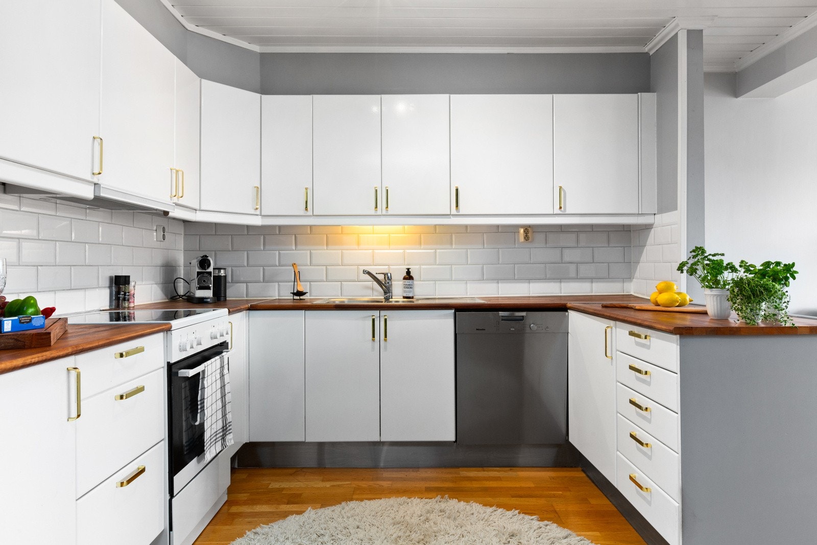 Kjøkkenet er praktisk utformet med slette fronter og en solid heltre benkeplate som gir god arbeidsflate. Galleribilde