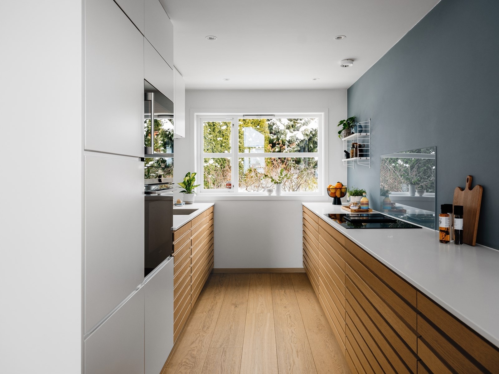 Moderne og tidsriktig Kvik-kjøkken fra 2019 med integrerte hvitevarer fra Siemens. Høyskap med slette, hvite fronter og benkeskap med eikefronter Galleribilde