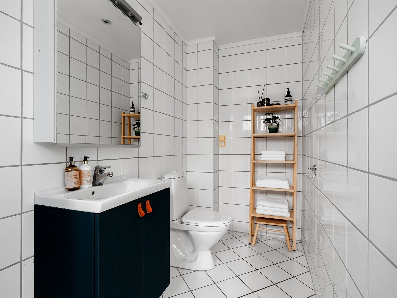 Helfliset bad i 2. etasje med varmekabler i gulv. Badet er innredet med toalett, baderomsinnredning med servant og speilskap, samt dusjkabinett Galleribilde