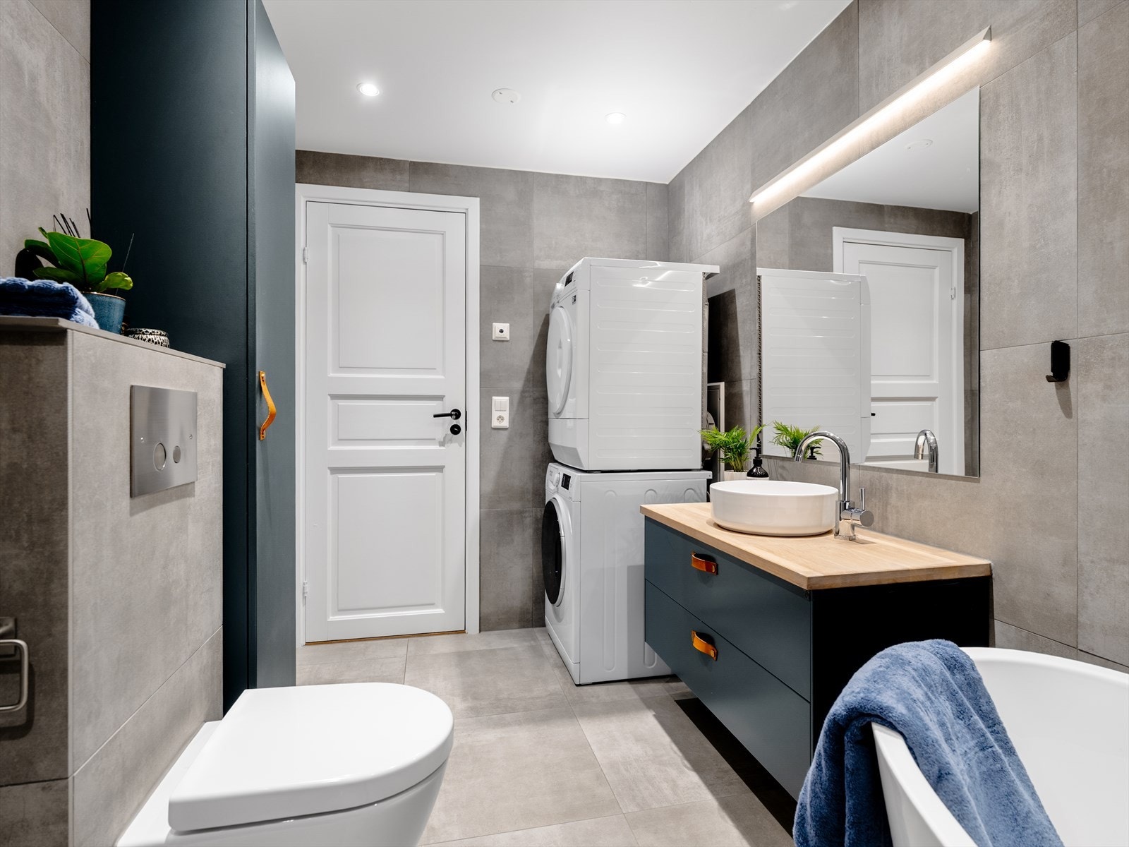 Det er opplegg og plass for både vaskemaskin og tørketrommel, noe som gjør badet både praktisk og funksjonelt Galleribilde