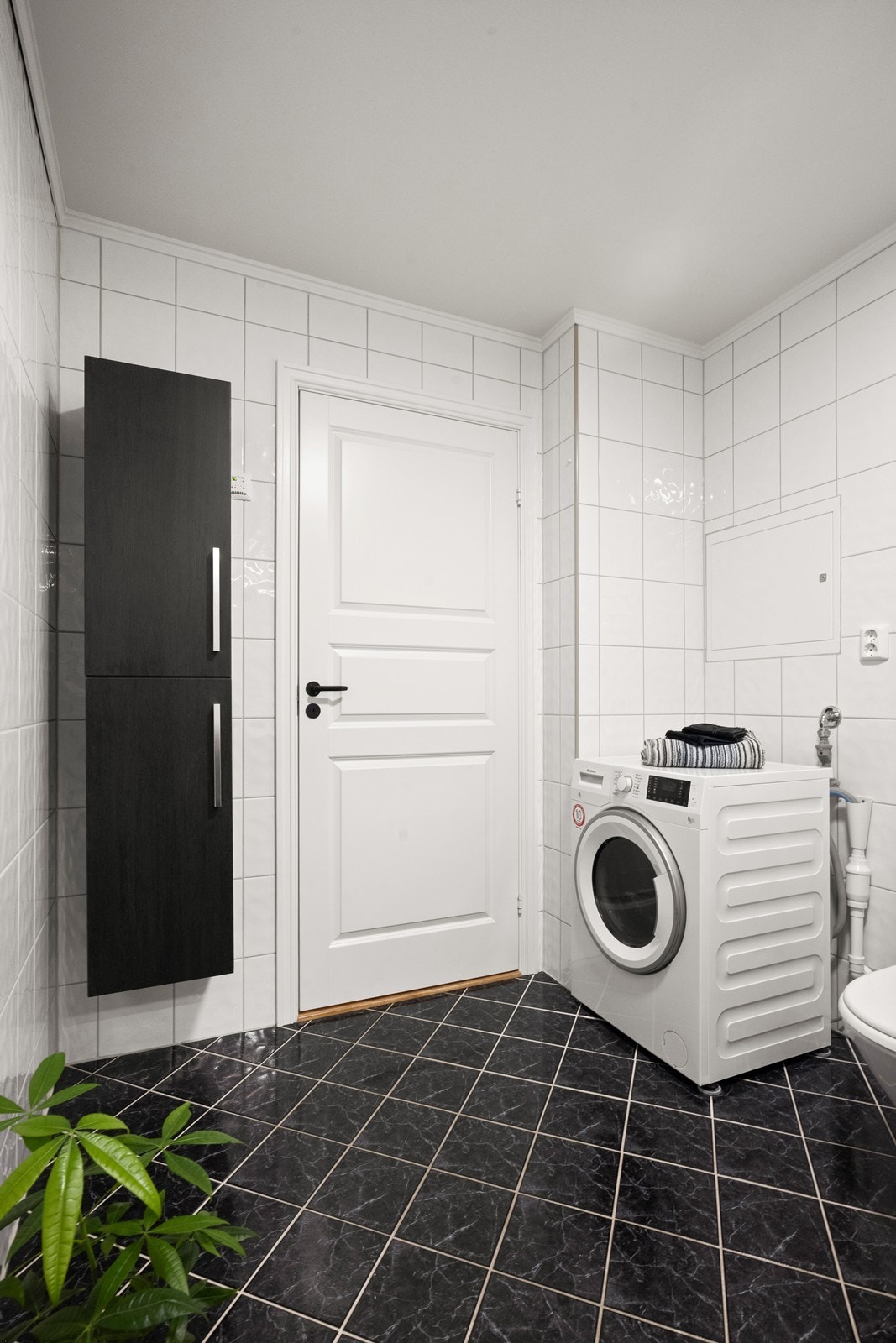 Rommet er utstyrt med dusjkabinett og har praktisk opplegg for vaskemaskin. Galleribilde