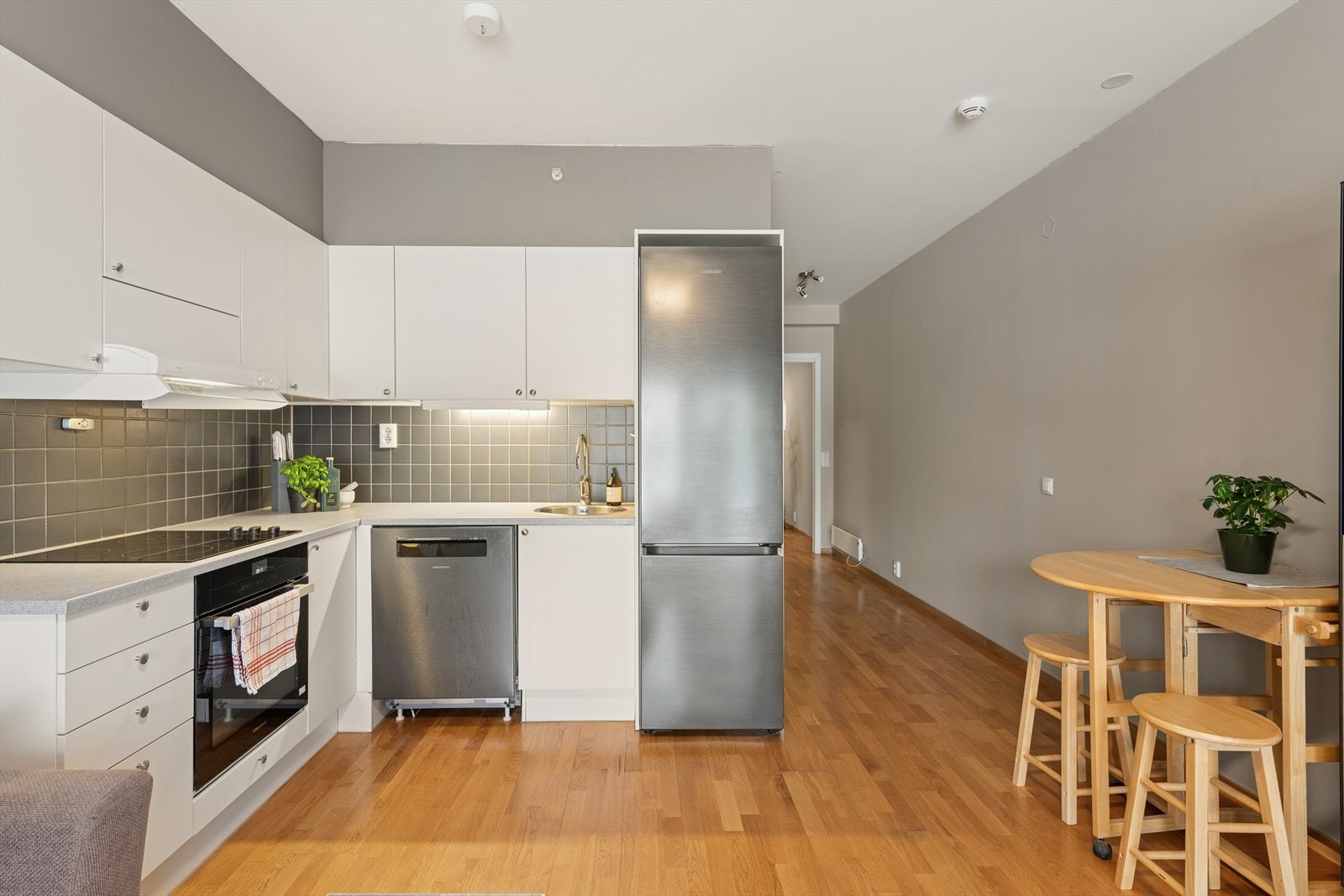 Kjøkkeninnredningen er fra byggeåret, og har slette, lyse fronter og laminerte benkeplater. Kjøkkenet er utstyrt med integrerte hvitevarer som komfyr og platetopp. Det er både opplegg og plass til oppvaskmaskin. Galleribilde