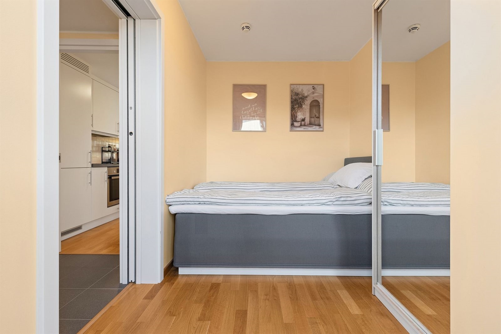 Lyst soverom med garderobeløsning med speilfront. Galleribilde