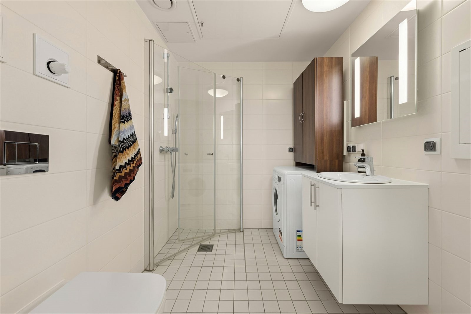 Pent flislagt bad av god størrelse. Det er opplegg for vaskemaskin og gode oppbevaringsmuligheter. Galleribilde