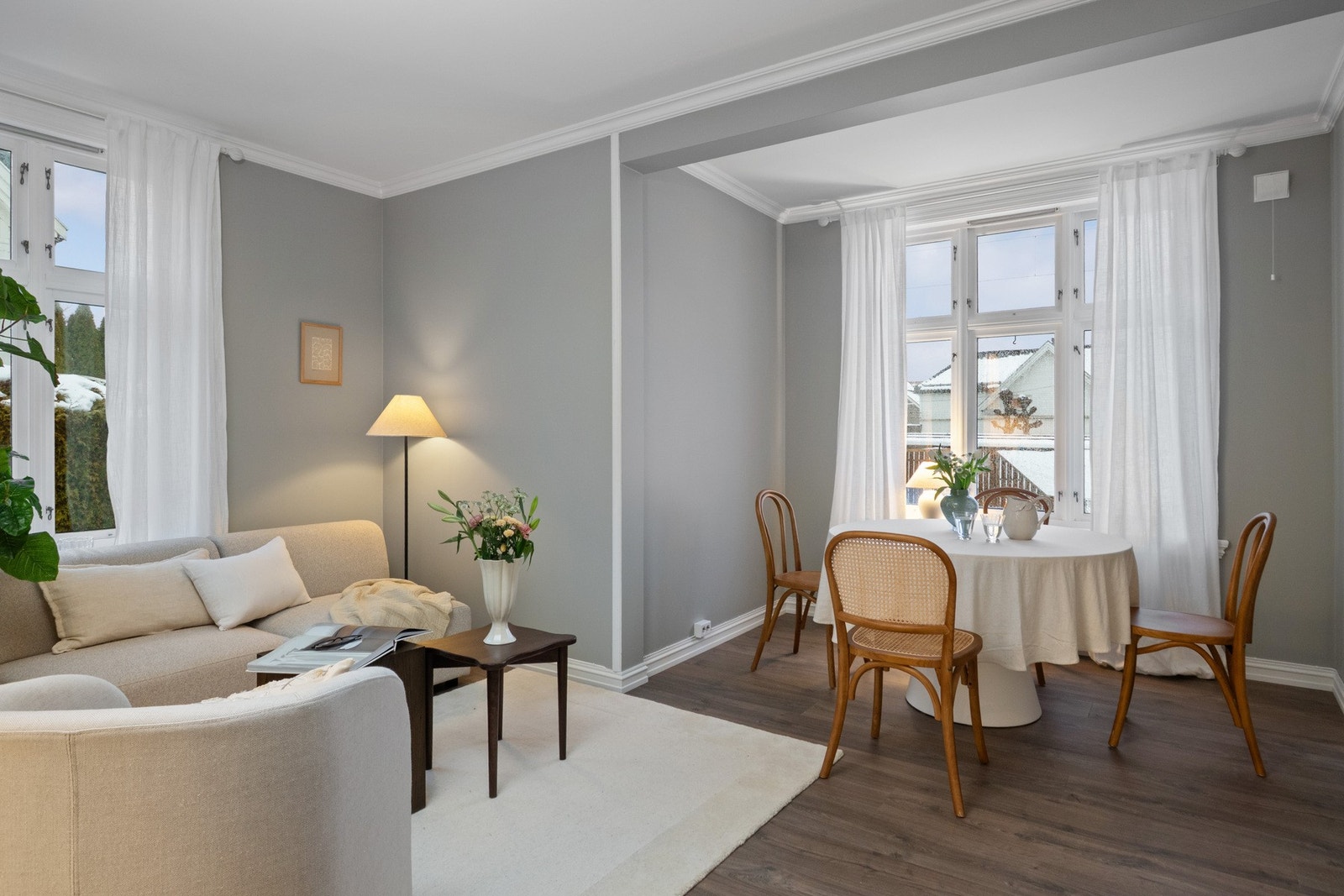 Lyse vegger kombineres med brede, hvite taklister og 1-stavs laminatgulv i mørk utførelse, noe som gir et stilrent og moderne uttrykk. Galleribilde