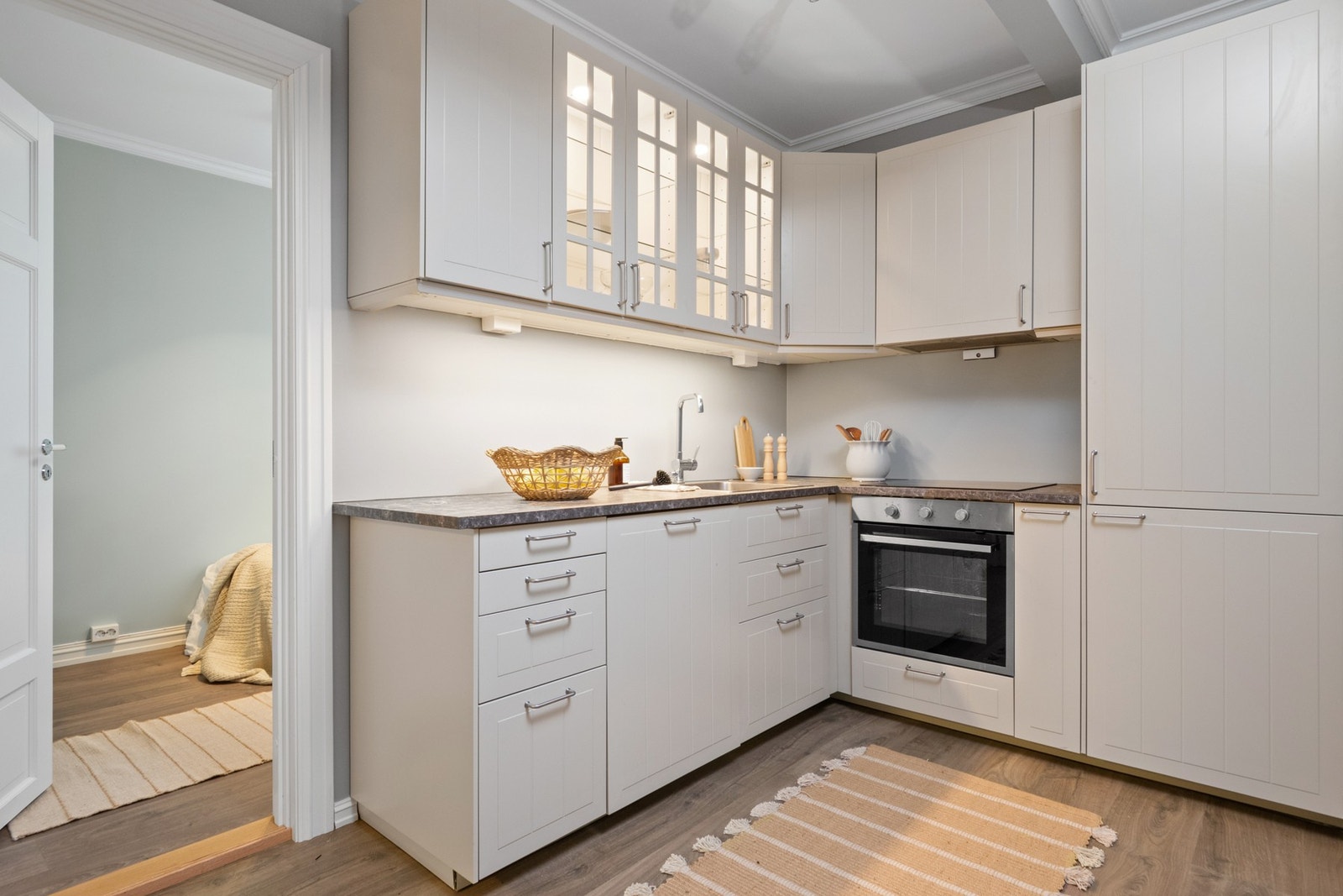 Innredningen er fra 2021 og består av profilerte fronter, vitrineskap og laminert benkeplate med nedfelt oppvaskkum i rustfritt stål. Galleribilde