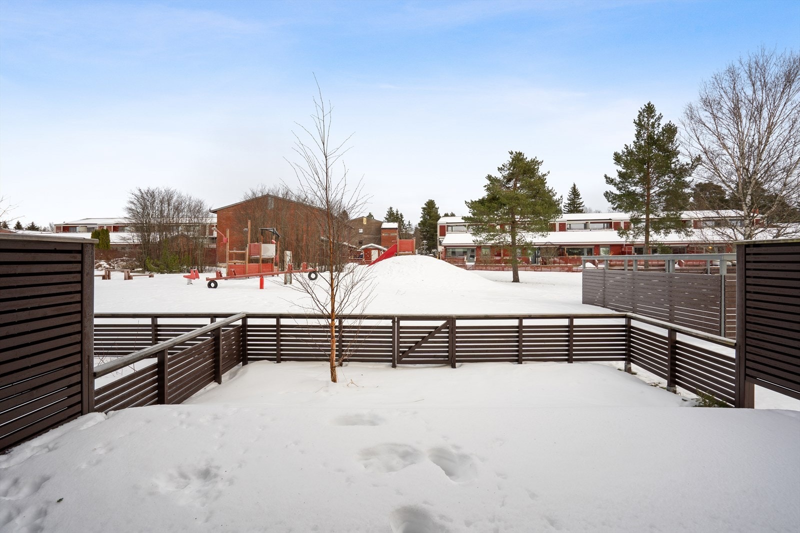 Fra terrassen har man utsikt over fellesarealet som er pent opparbeidet med grøntarealer og lekeplass. Galleribilde