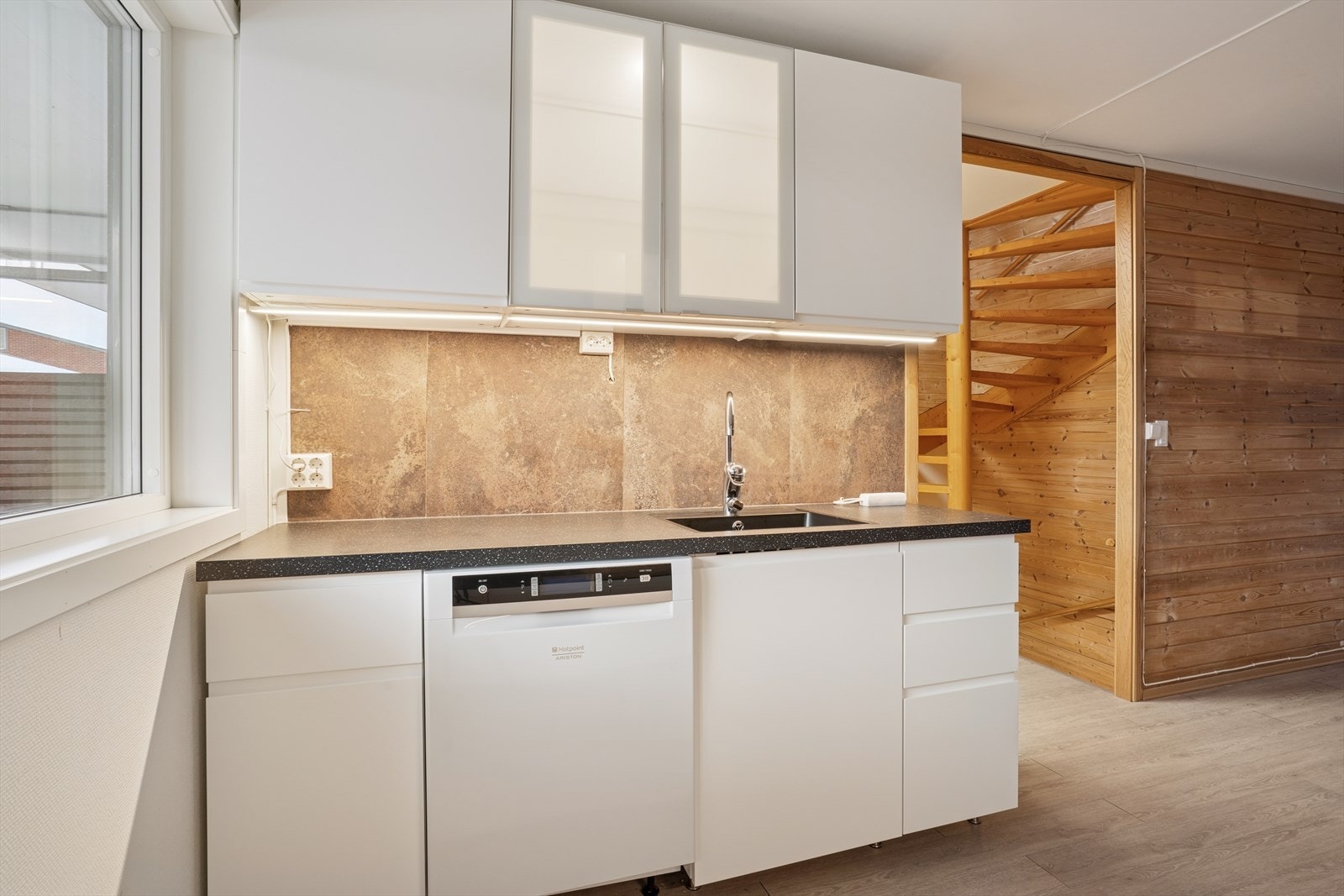 Plater bak kjøkkenbenken gjør det praktisk å holde det rent med mat- og vannsøl. Galleribilde