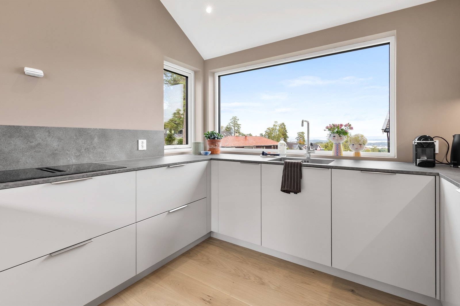 Moderne kjøkken med rene linjer og en storslått utsikt. Galleribilde