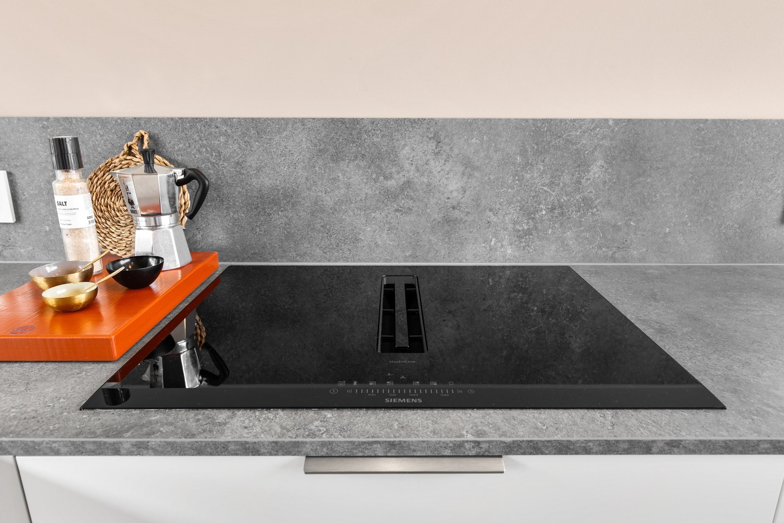 Integrert kjøleskap med fryser, oppvaskmaskin, mikrobølgeovn, stekeovn og induksjonstopp med kullfilterventilator i senter. Galleribilde