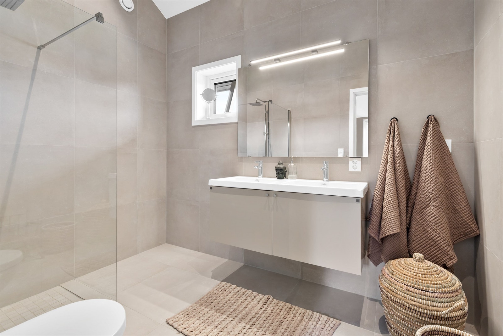 Baderom fra byggeår. Flislagt gulv med varme og flislagte vegger. Nedsenket himling med downlights. Vegghengt servantskap. Galleribilde