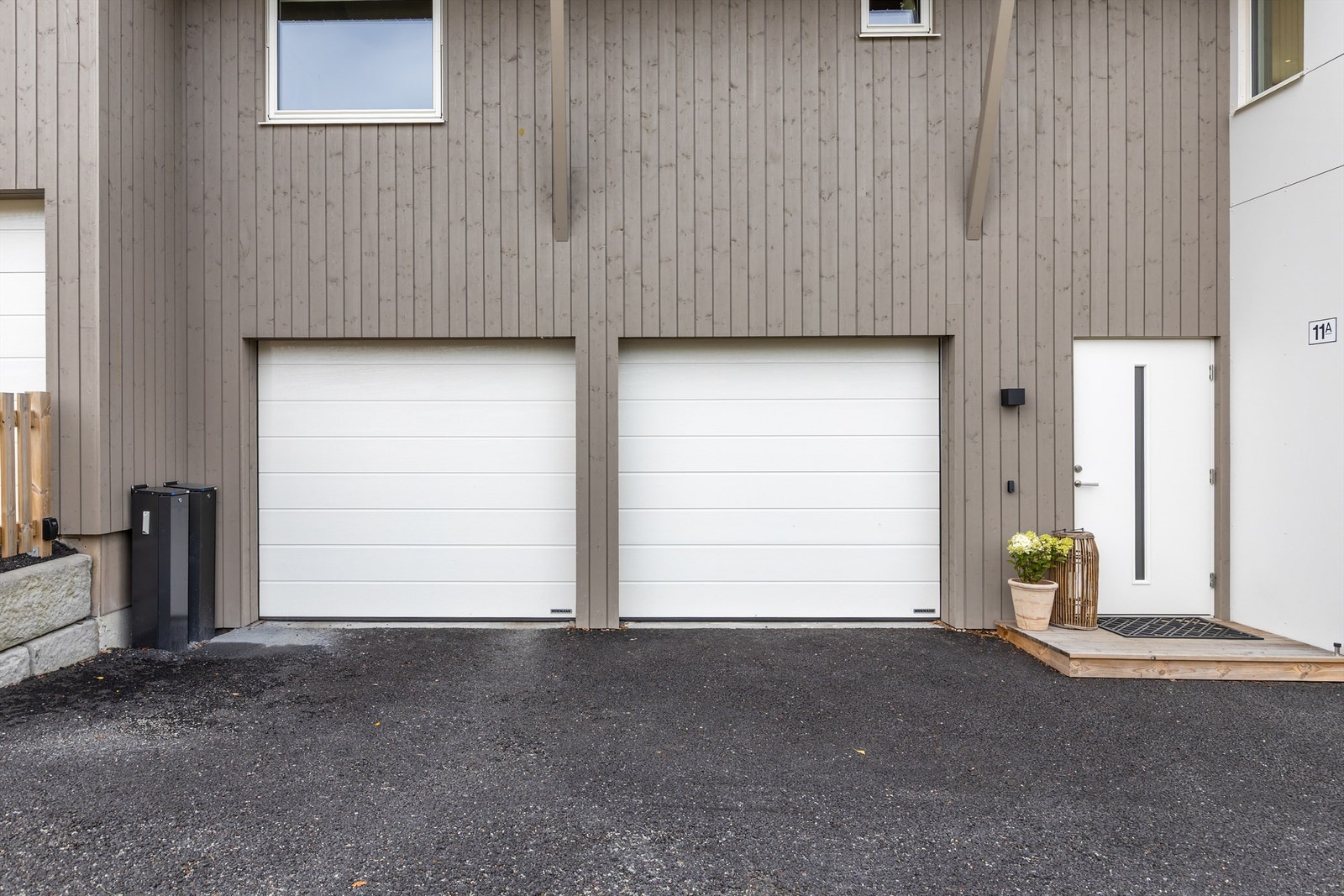 Tøff, moderne fasade med dobbelgarasje og asfaltert gårdsplass. Galleribilde