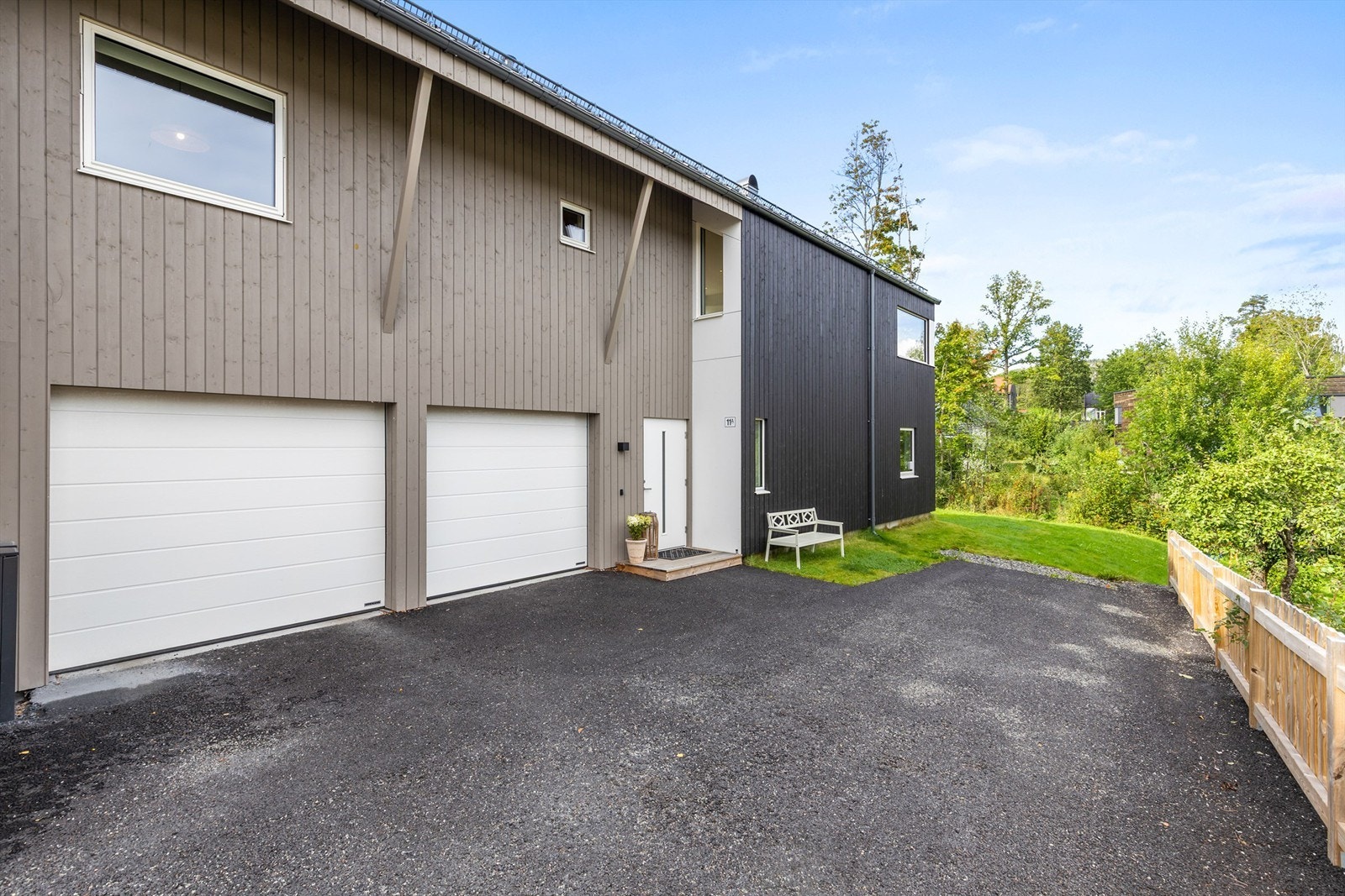 Tøff, moderne fasade med dobbelgarasje og asfaltert gårdsplass. Galleribilde