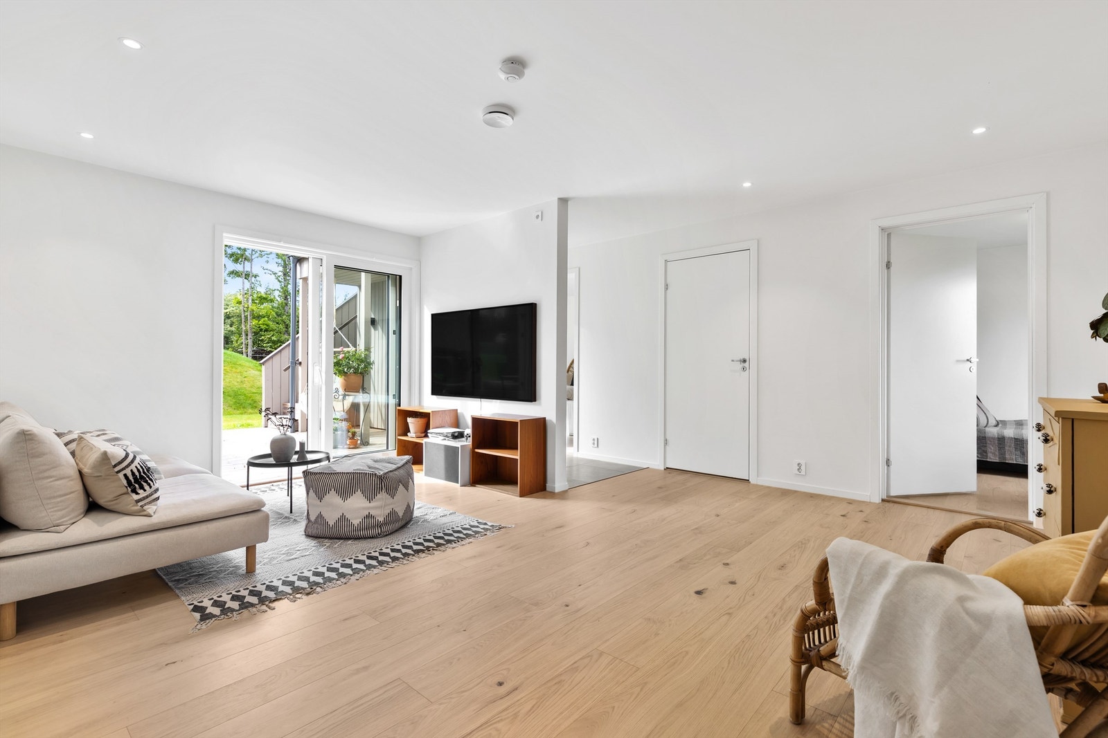 Herlig romfølelse med brede gulvplanker og skyvedør ut mot det grønne. Fra TV-stuen er det tilgang til 3 soverom, bad, markterrassen, samt trapp opp til 2.etasje. Galleribilde