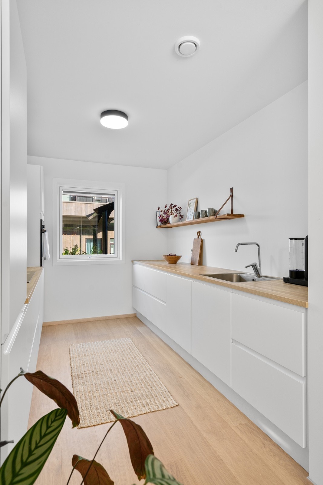 Lekkert lyst kjøkken med god benk - og oppbevaringsplass Galleribilde