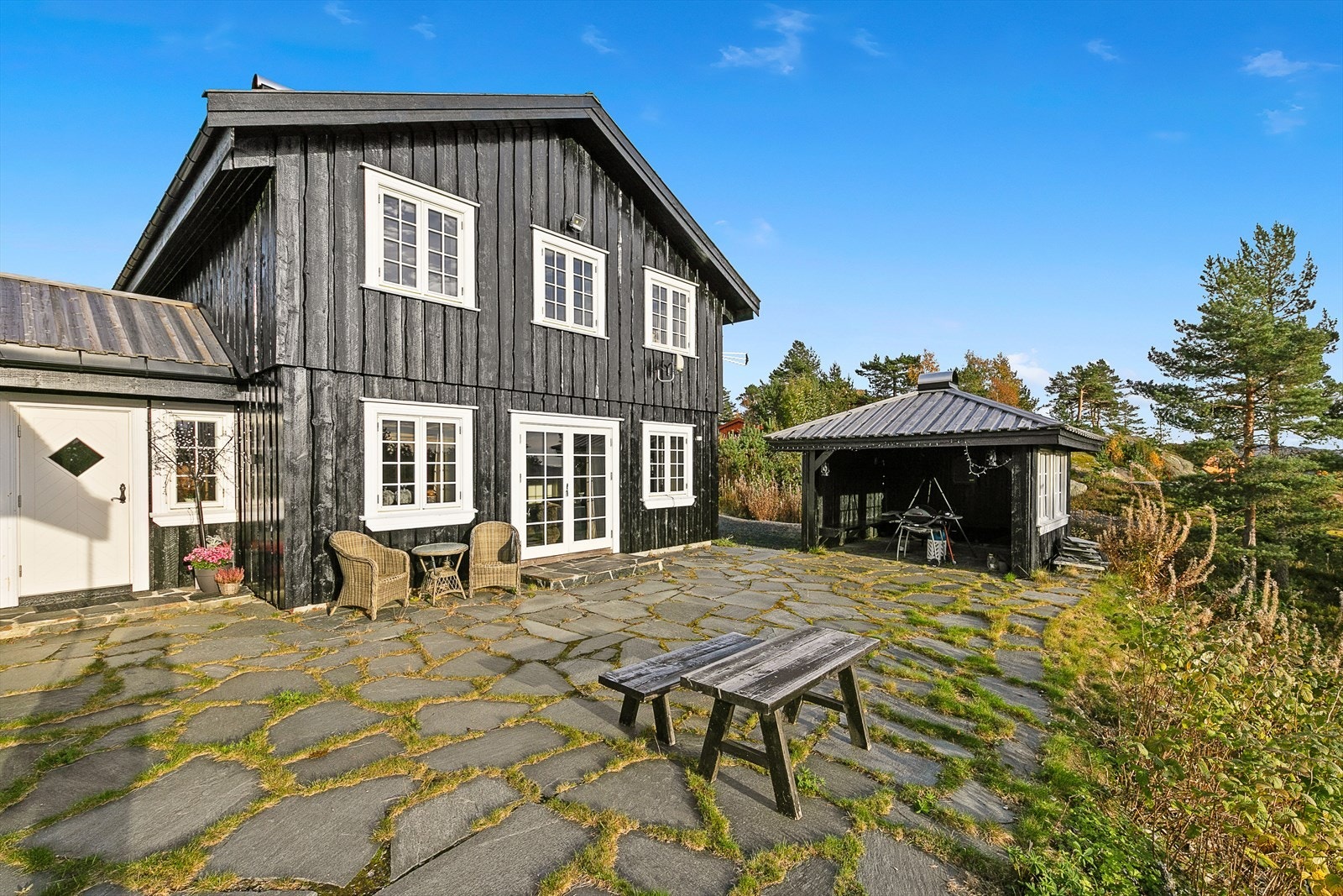 Uteplassen ligger usjenert til og er anlagt med flotte skiferheller, i direkte tilknytning til inngangspartiet og begge stuene. Galleribilde