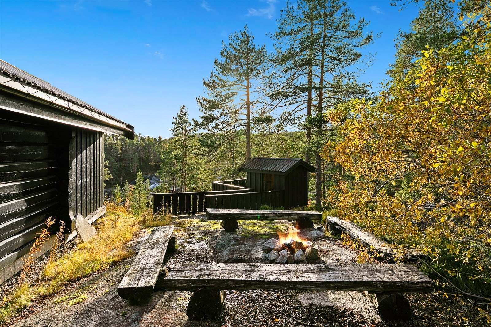 Nordvest for hytta er det etablert en trivelig bålplass med benker, samt en gangbru som leder til en liten lekestue/bod. Galleribilde