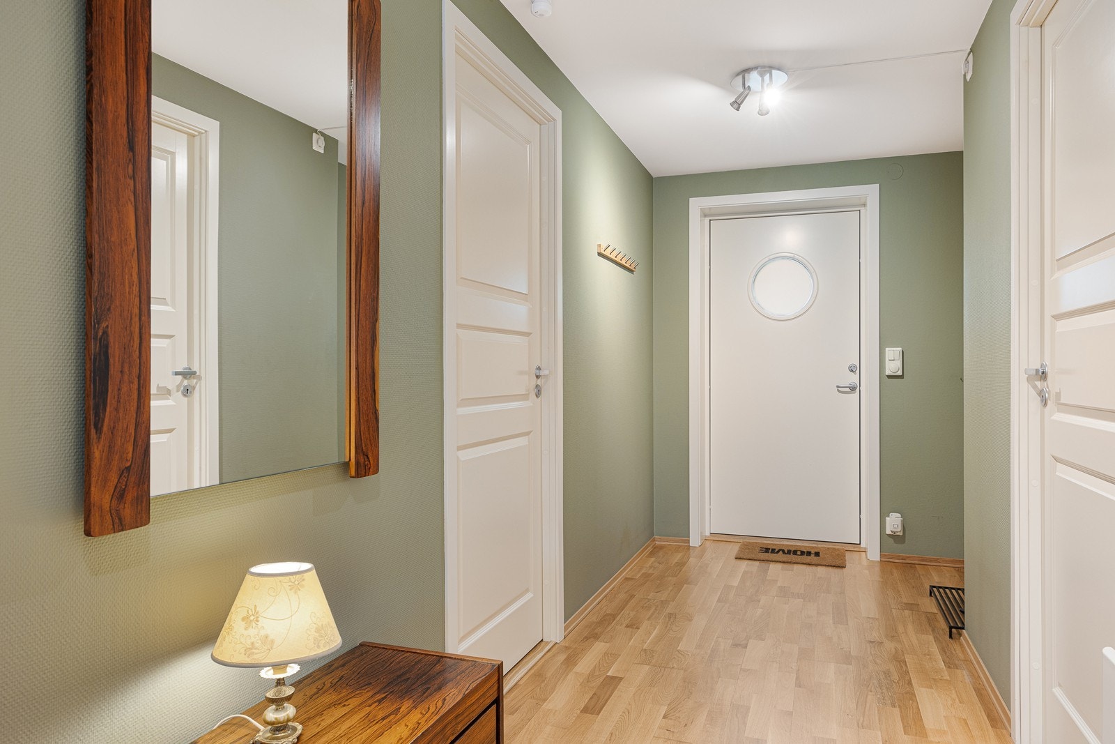 Den pene entreen har grønnmalte vegger og gyllent, trestavs parkettgulv. I en nisje er det plass til garderobeløsning. Galleribilde