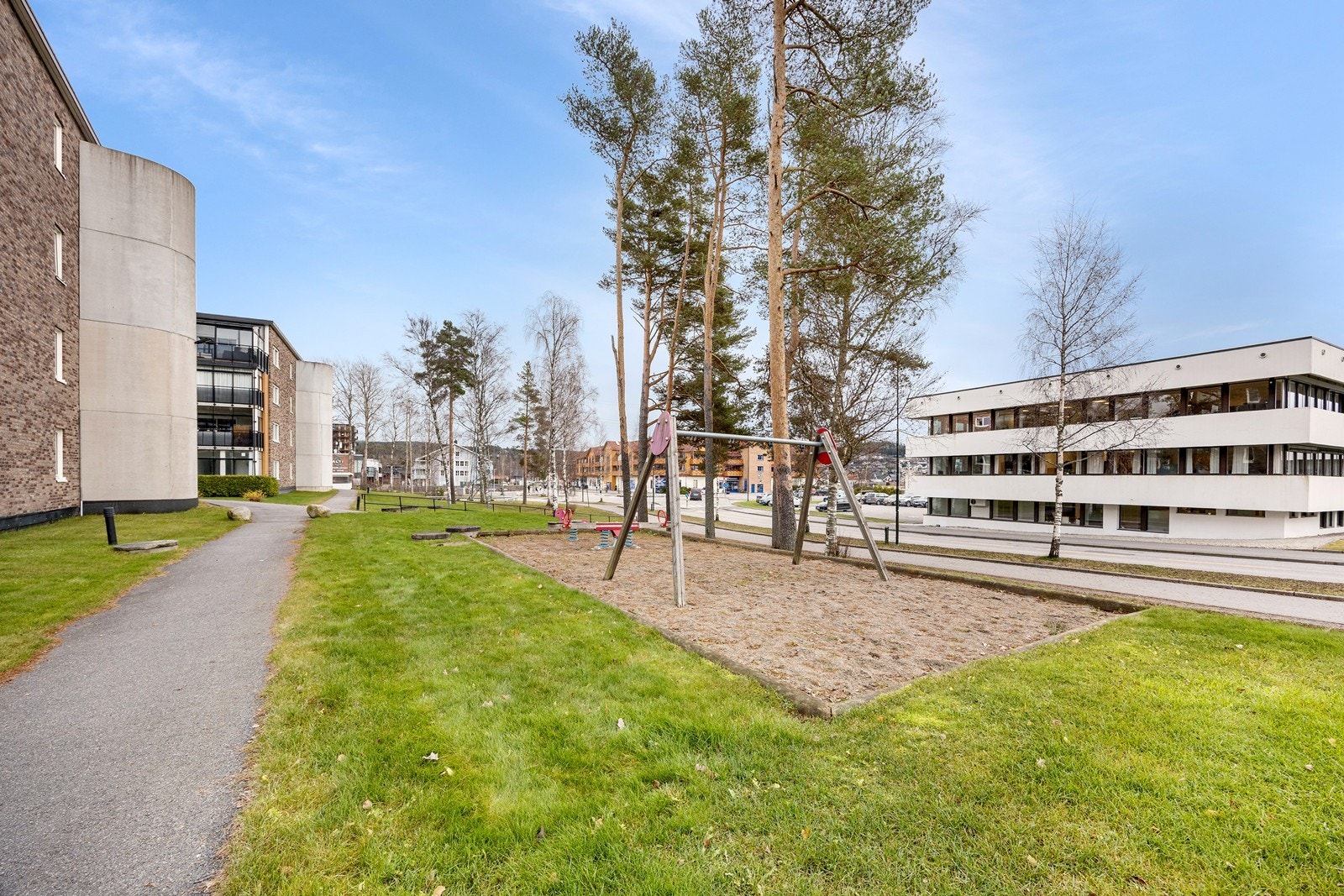 Blant det grønne er det asfalterte arealer, lekeplasser og sittebenker. Det er "tøffelavstand" til sentrum med apotek, lege, forretninger, frisør, vinmonopol, bibliotek, kafeer m.m. Galleribilde